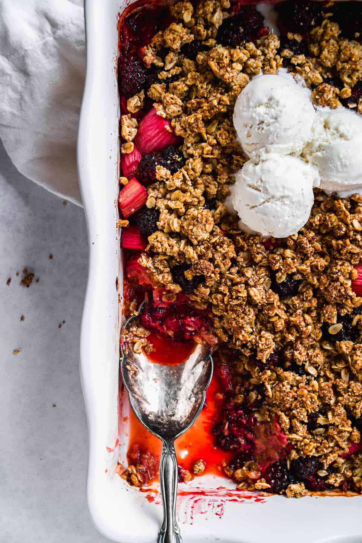 Overhead view of gluten free rhubarb crisp with a serving spoon inside.