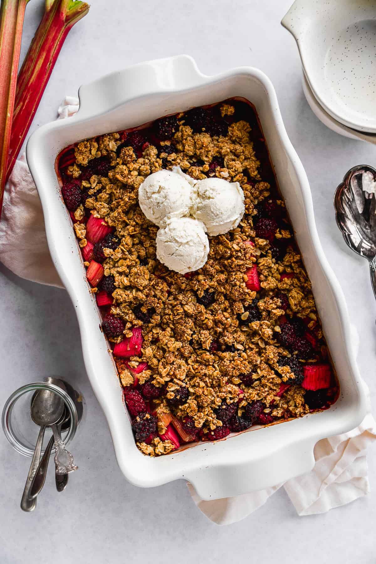 Baked gluten free rhubarb crisp with three scoops of ice cream on top.