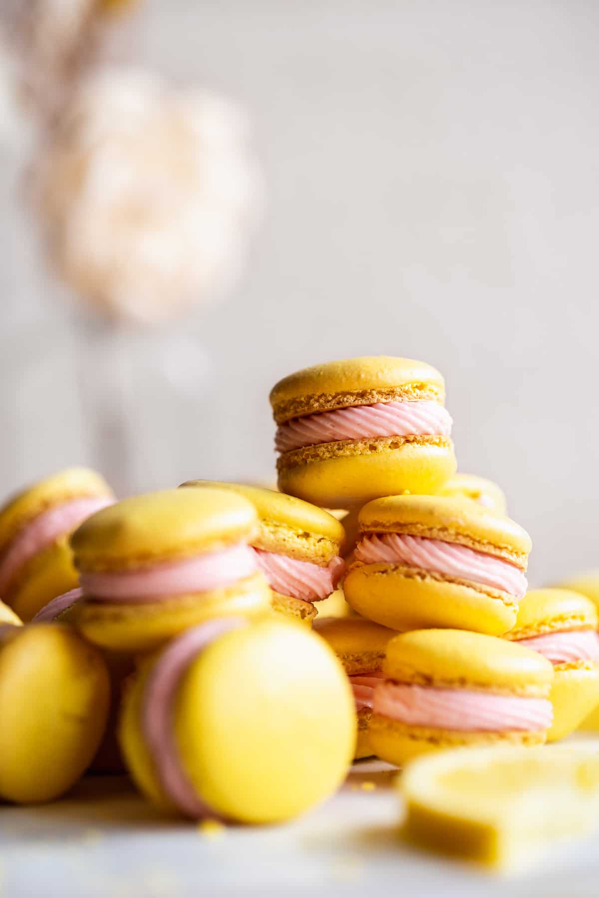 Stack of pink lemonade macarons on a white surface.