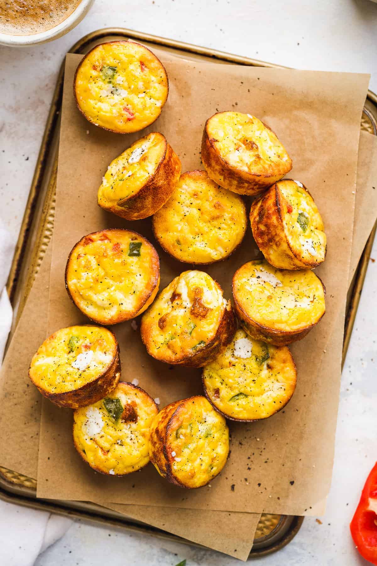 Overhead view of ricotta egg bites on a baking pan with paper.