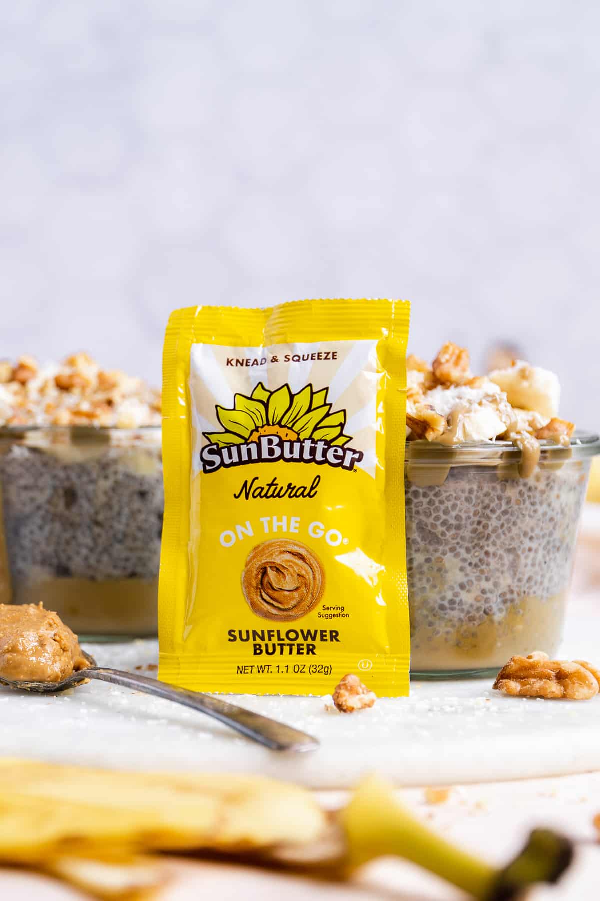 Yellow pouch of sunflower butter resting next to a jar of chia seed pudding.