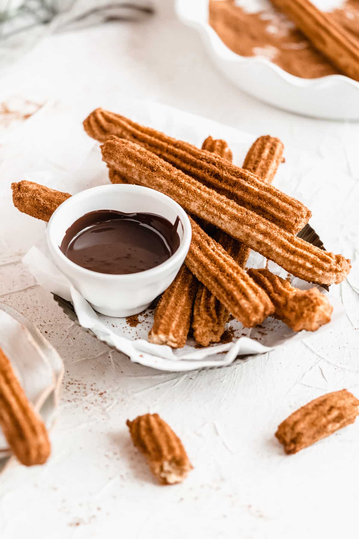 Basket of baked churros with bowl of melted chocolate.