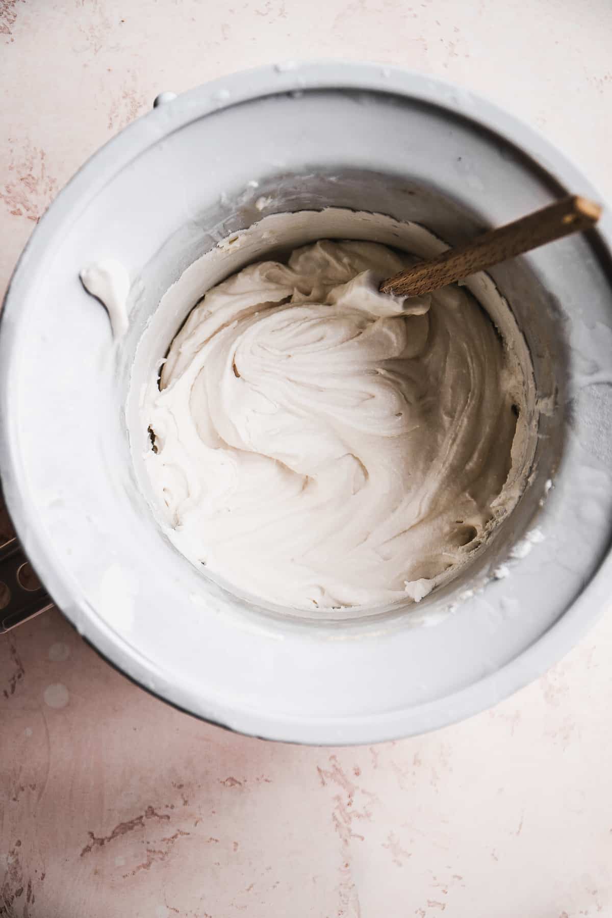 Overhead view of an ice cream maker with dairy free vanilla ice cream inside.