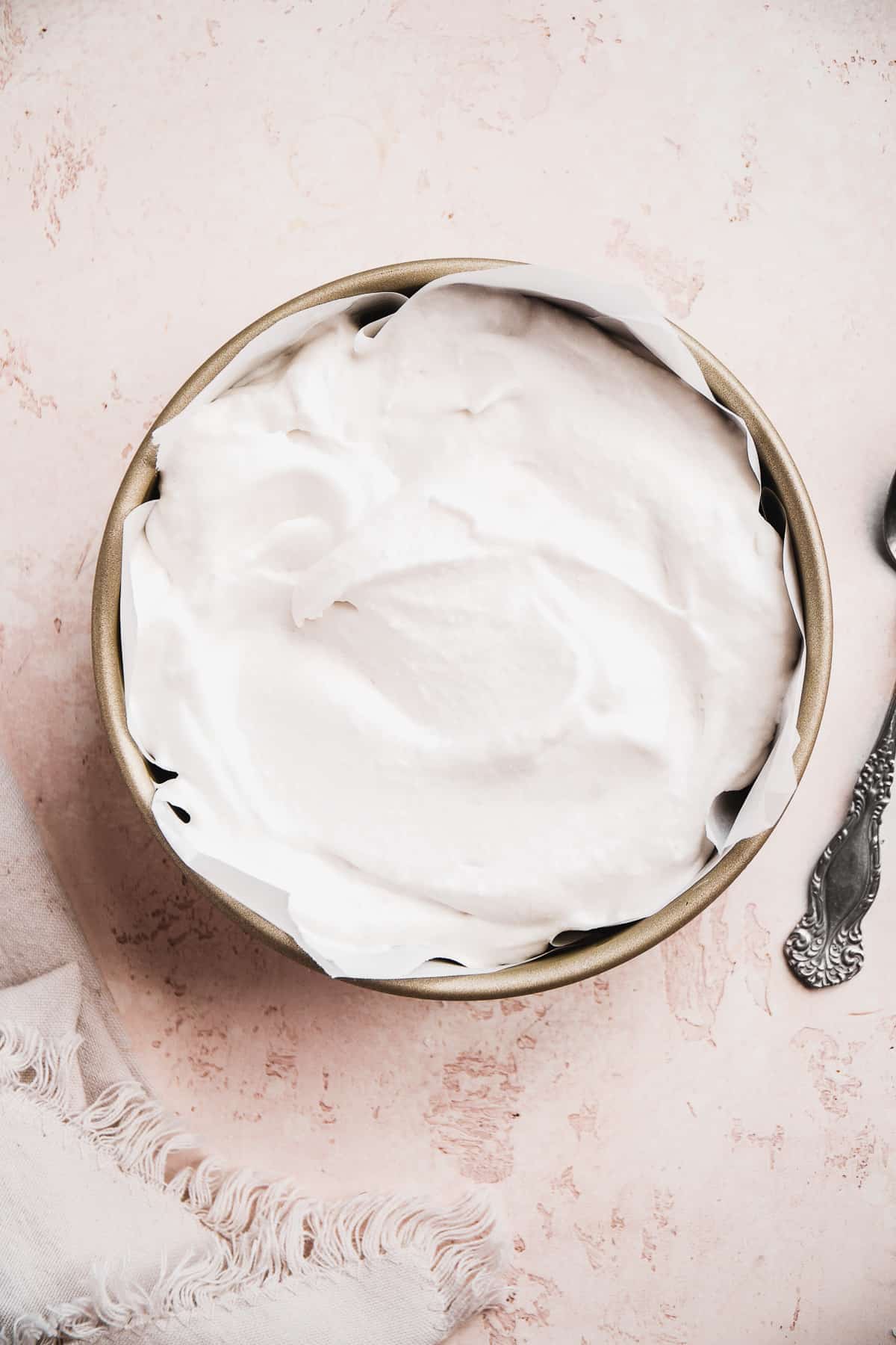 Container with vegan ice cream inside and a spoon off to the side.