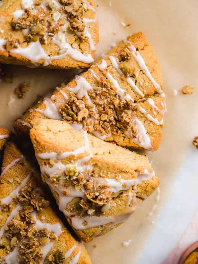 Pumpkin scones drizzled with icing scattered on a white surface