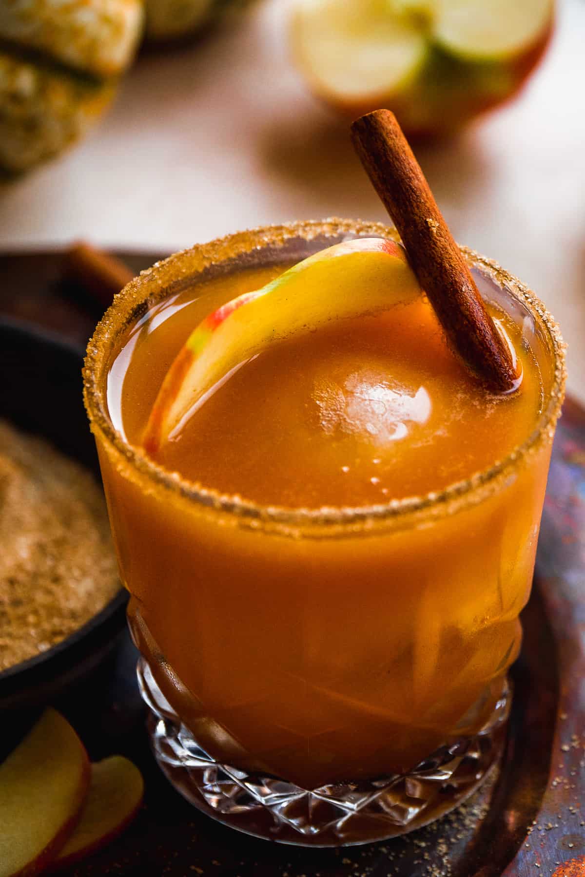 Up close image of a pumpkin cocktail with cinnamon stick inside.