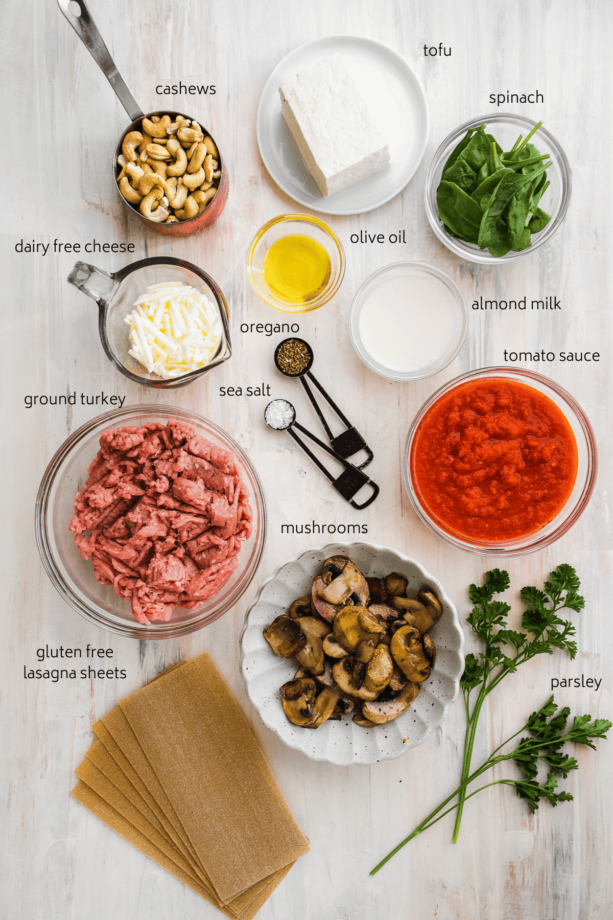 Image of lasagna ingredients on a light surface with labels in black.