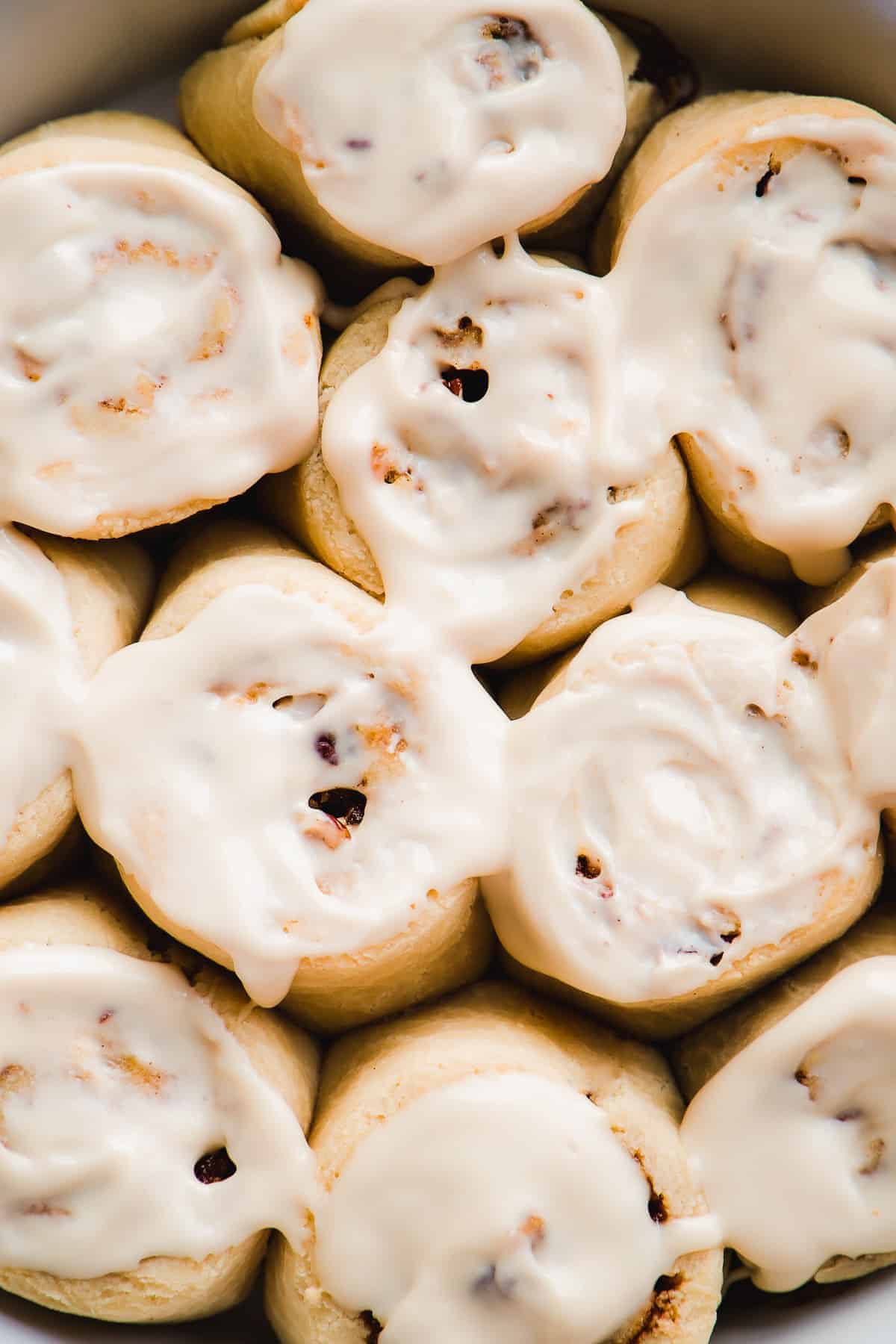 Up close overhead view of cinnamon rolls with icing.