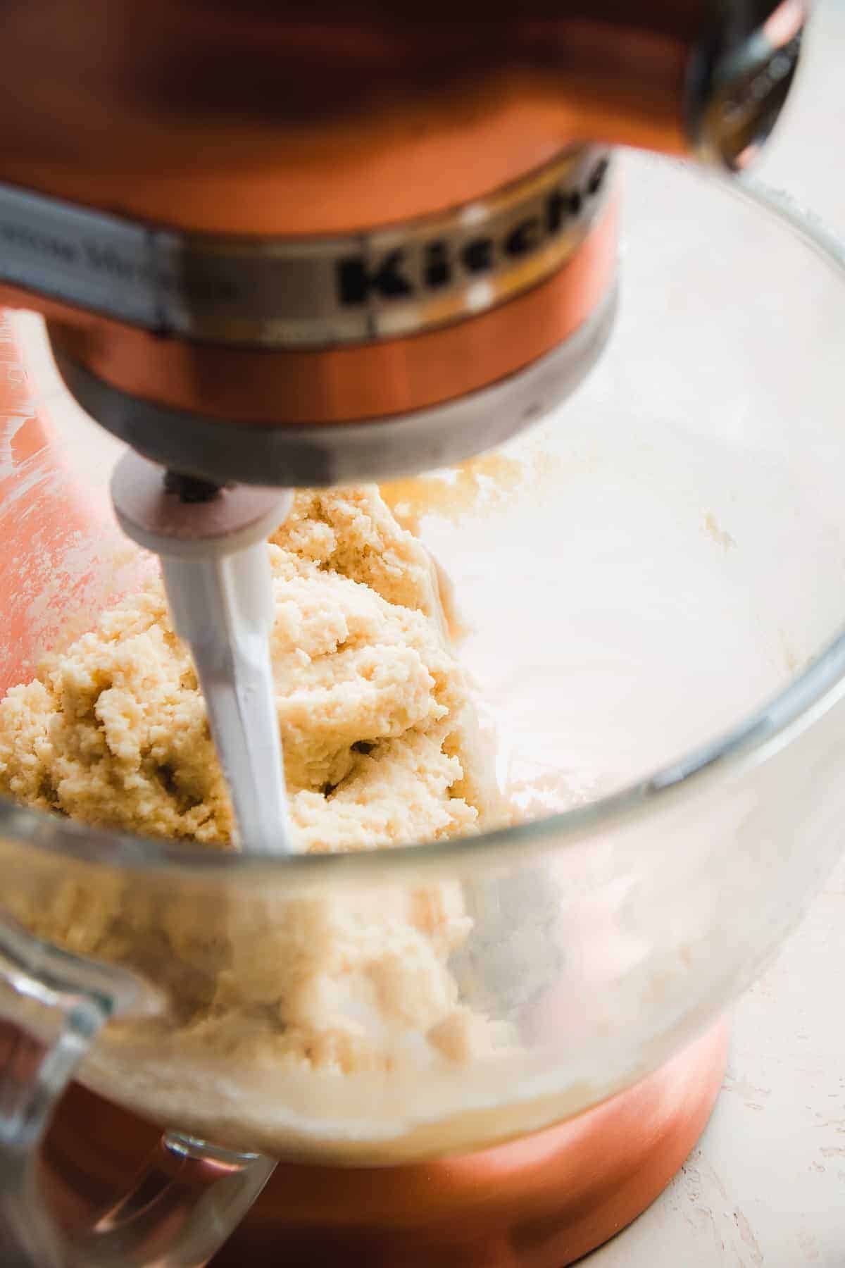 Glass mixing bowl with dough inside.