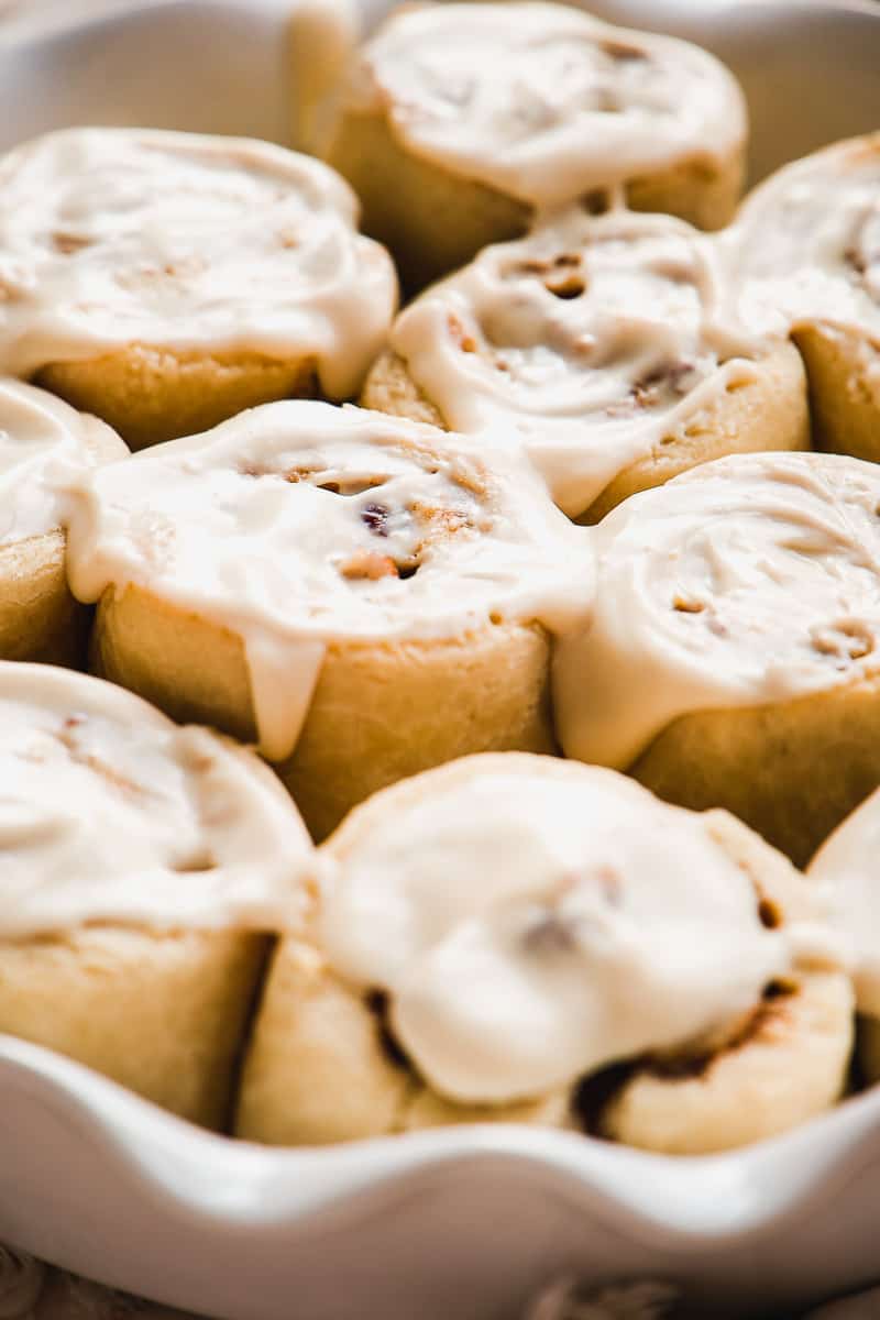 Up close view of cinnamon rolls baked in a dish with icing.