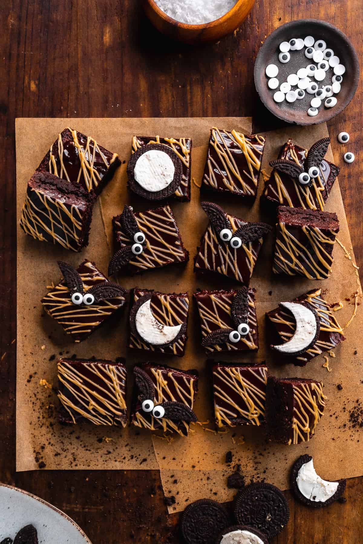 Overhead view of brownies cut into squares with almond butter drizzle and brownies on top made out of Oreos.