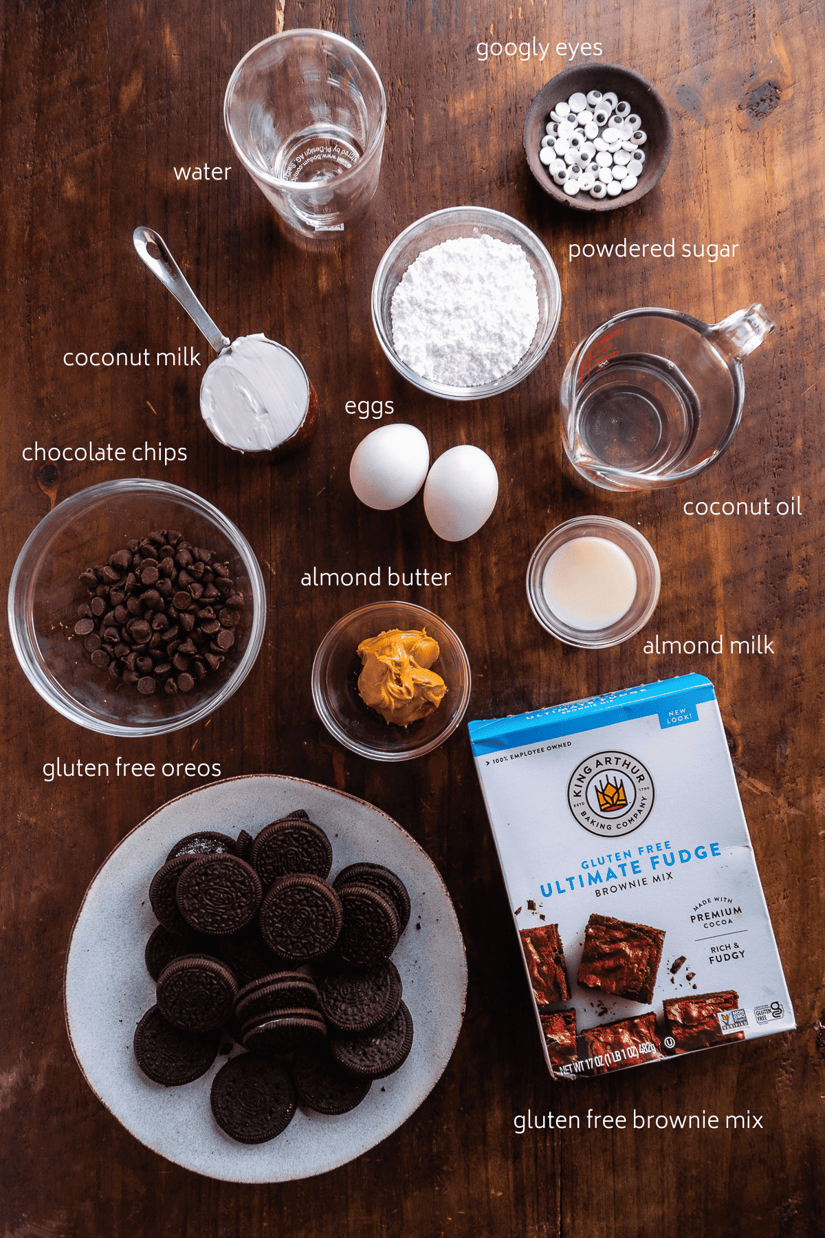 Brownie ingredients on a wooden surface with white labels.