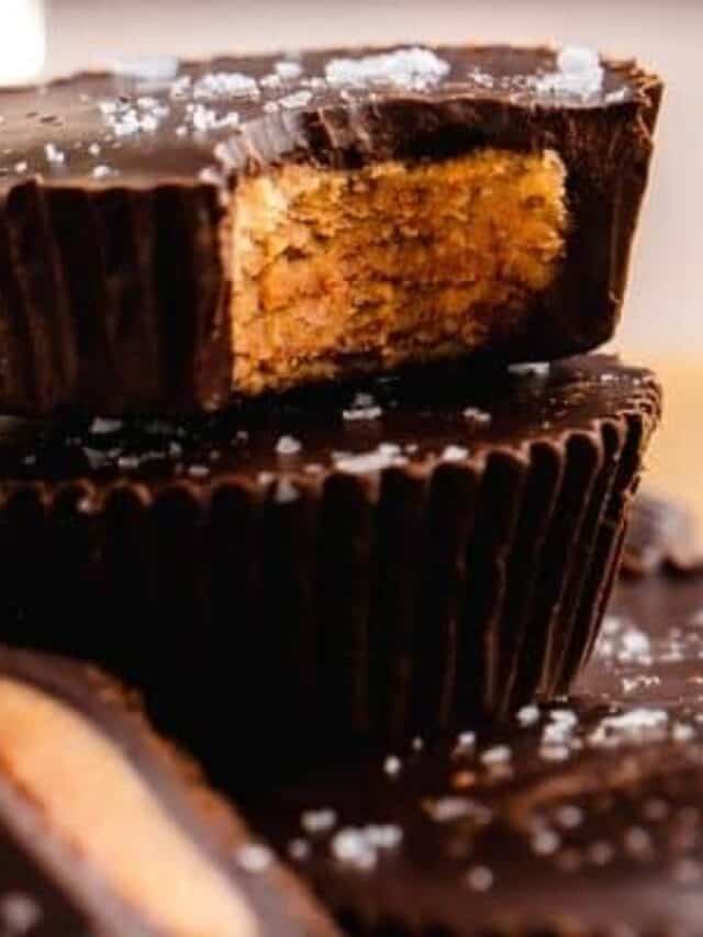 Stack of peanut butter cups with sea salt on top and bite taken out of one.
