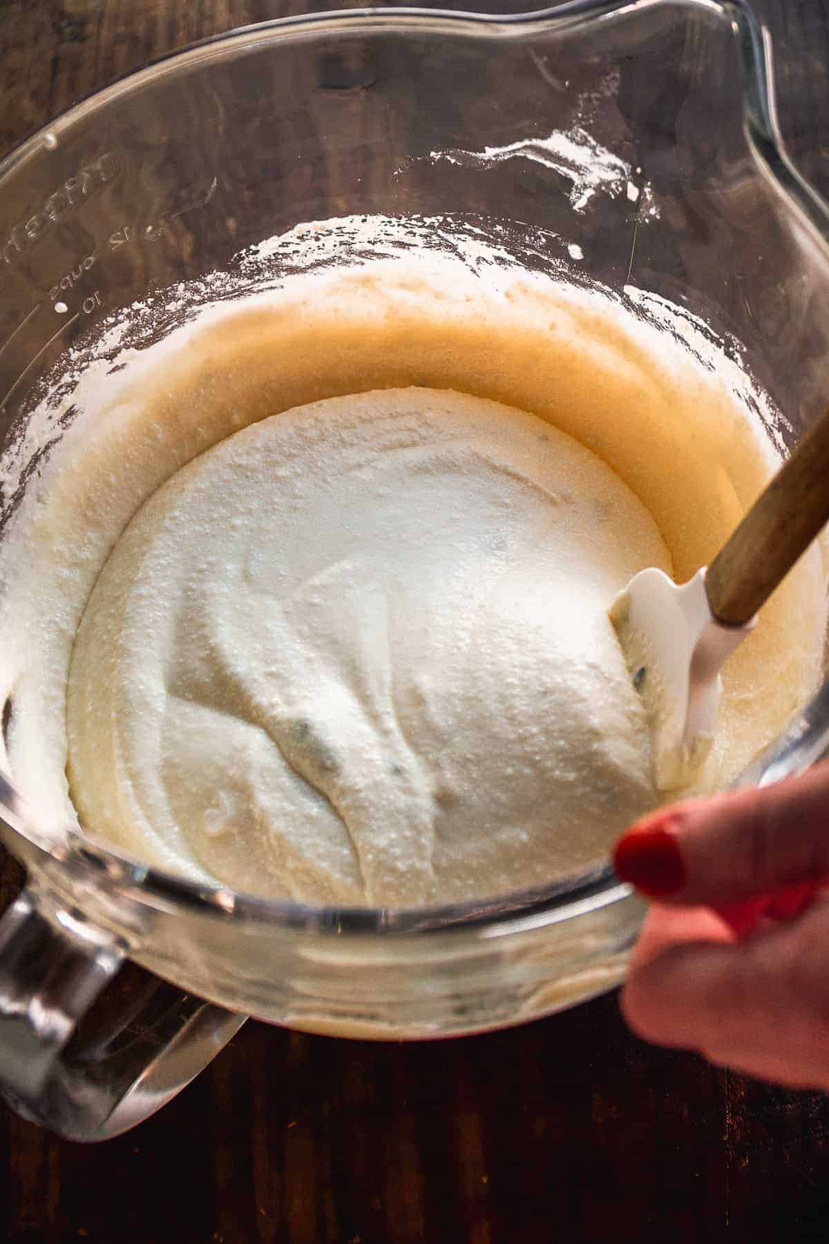 Person mixing ricotta dip in a mixing bowl.