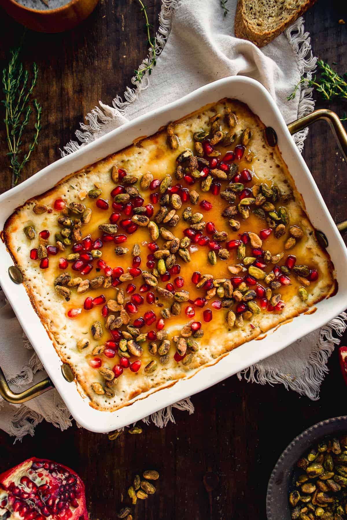 Overhead view of baked ricotta with honey and toppings.