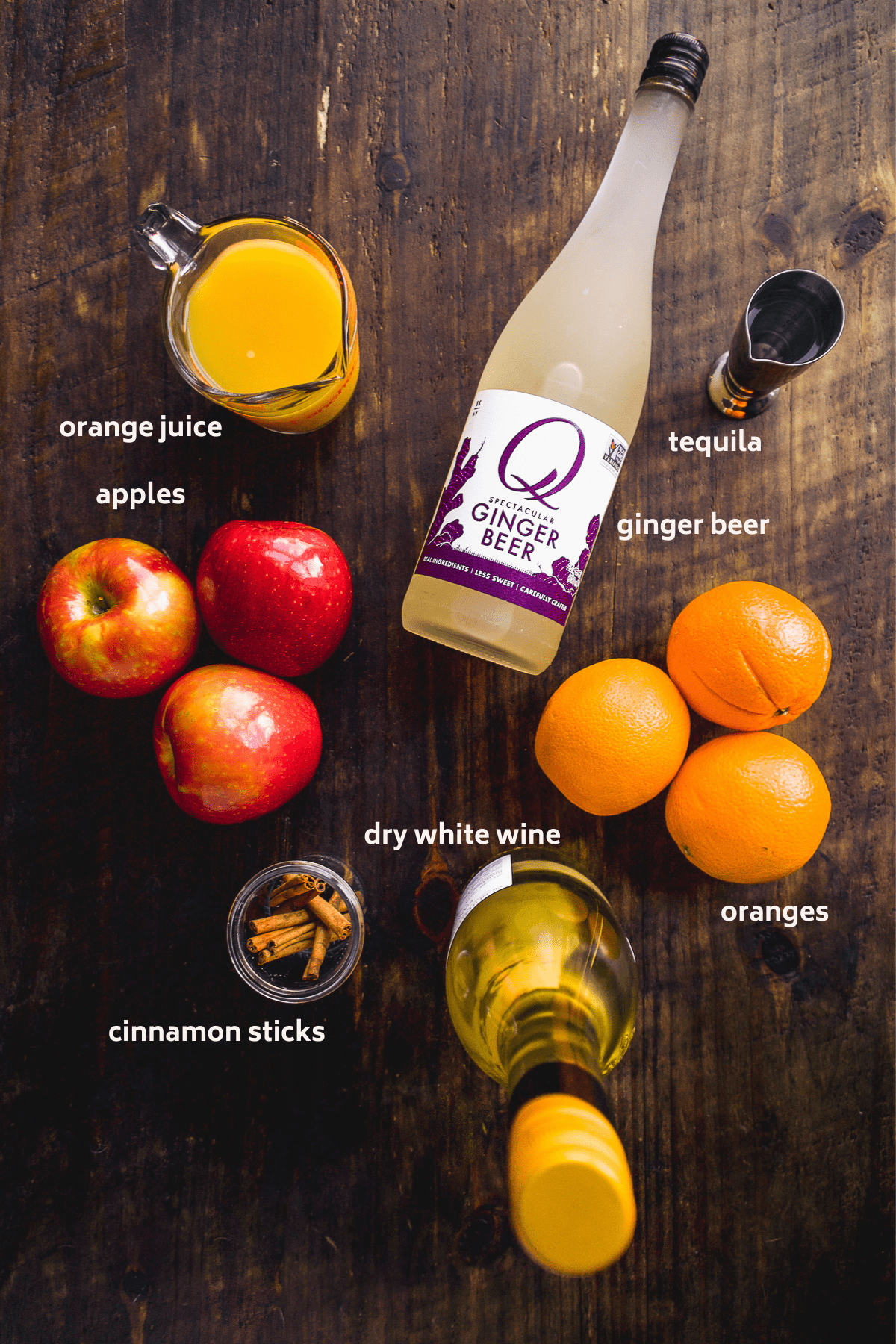 Image of thanksgiving sangria ingredients on a wooden surface with labels in white.