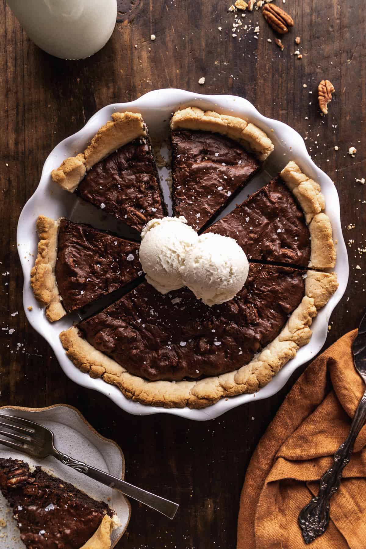 Overhead view of a gluten free chocolate brownie pie with ice cream on top.