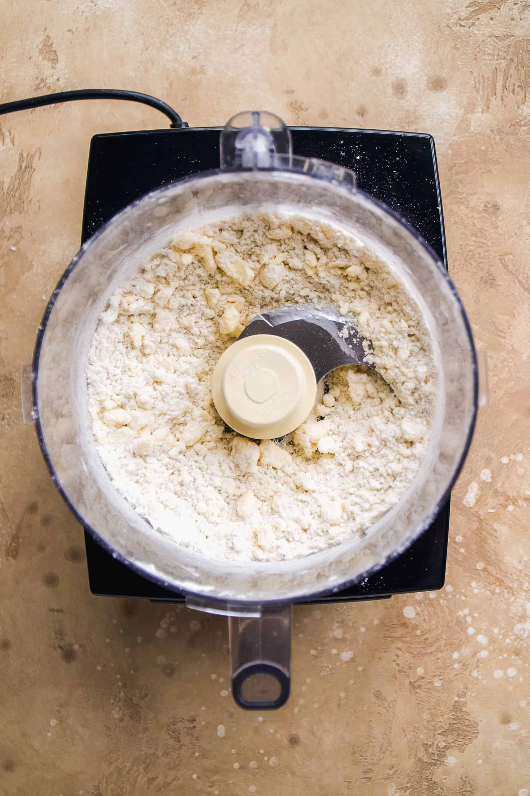 Overhead view of a food processor with gluten free dough being made.