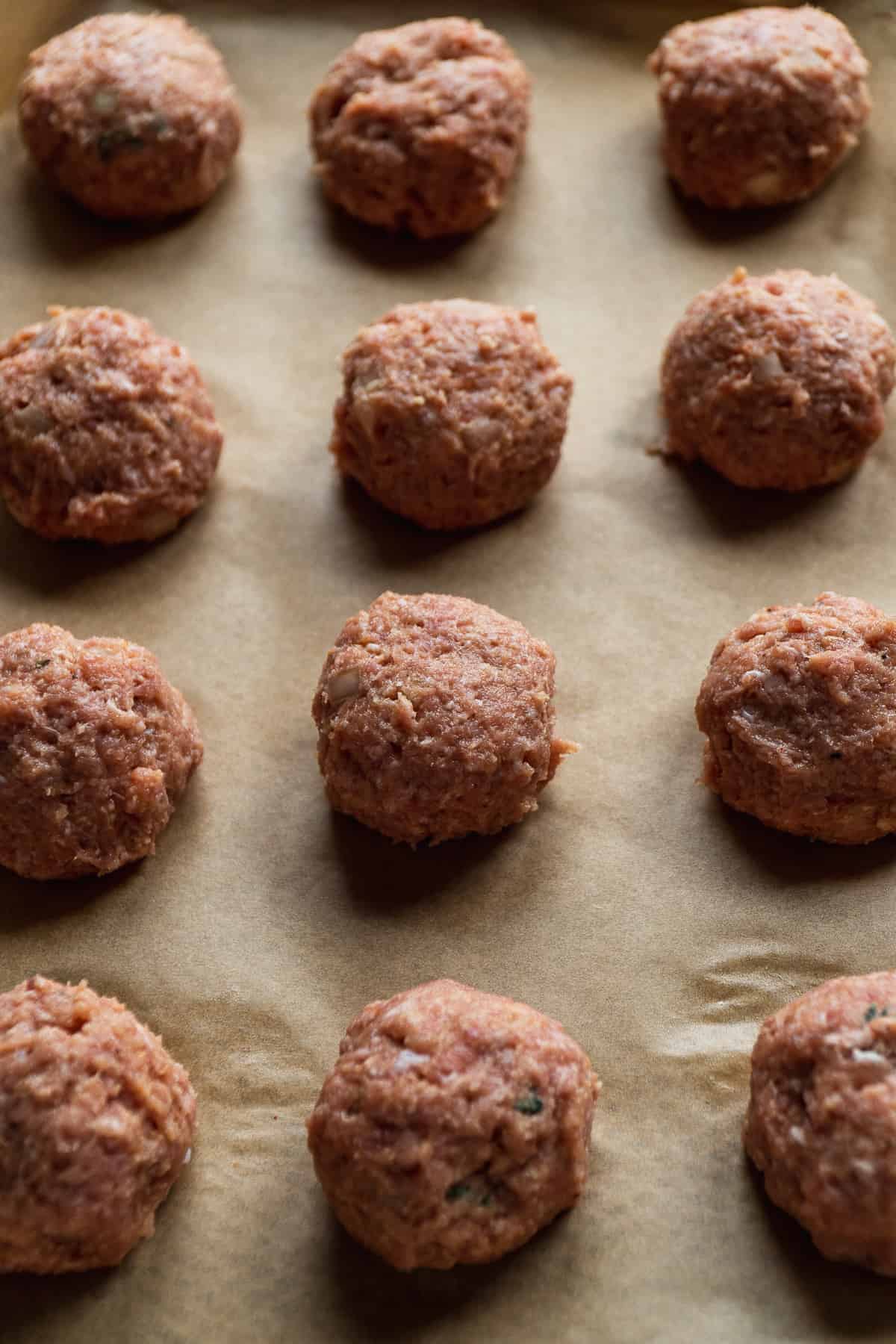 Turkey meatballs on a baking sheet about to be baked.