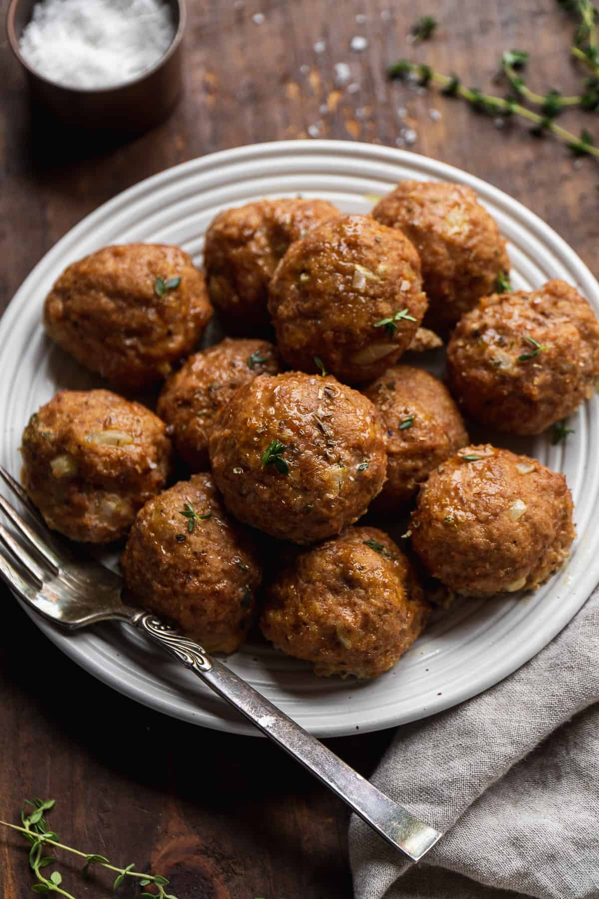 Baked gluten free turkey meatballs on a plate with a fork.