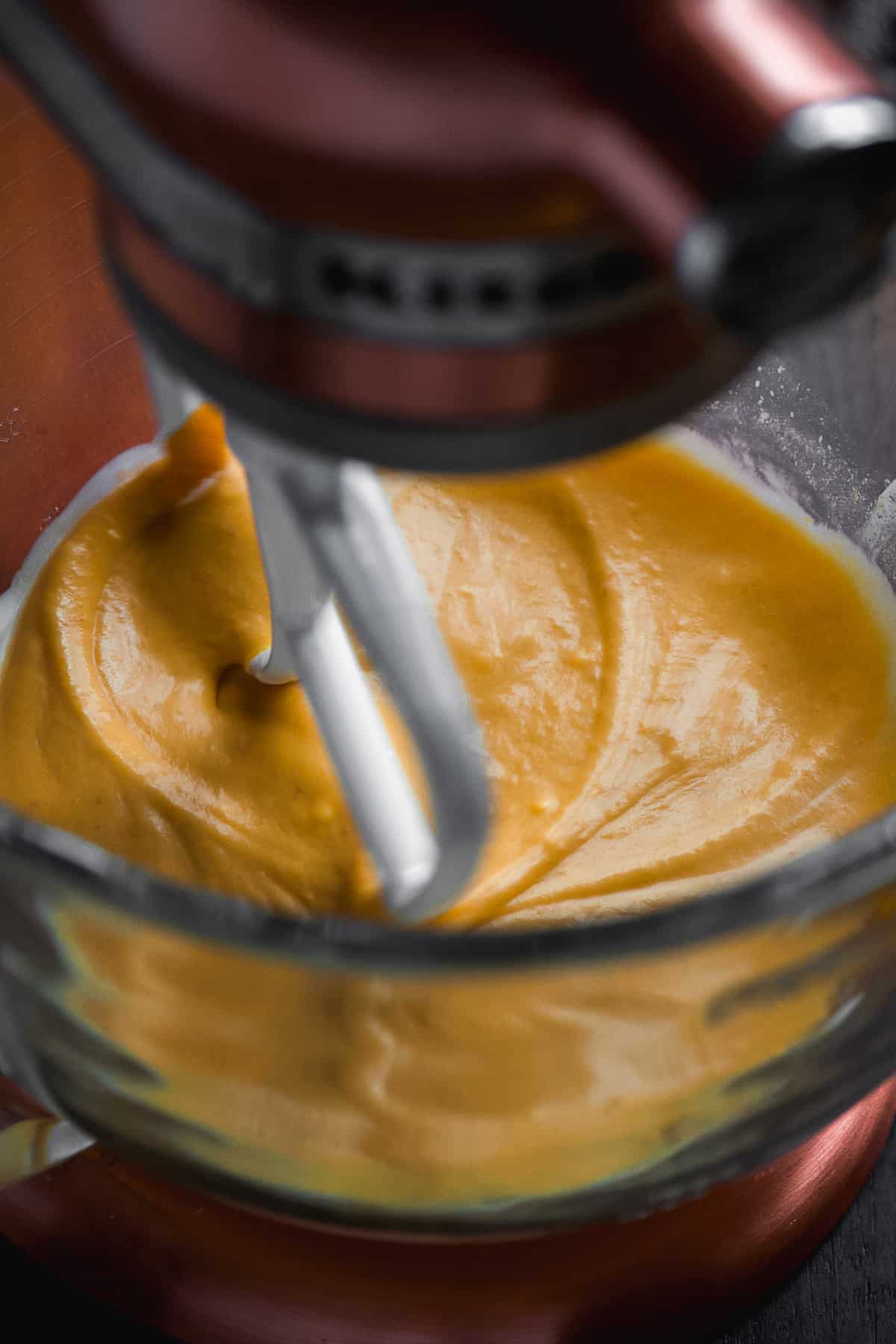 Mixing bowl with pumpkin cinnamon roll ingredients being mixed.