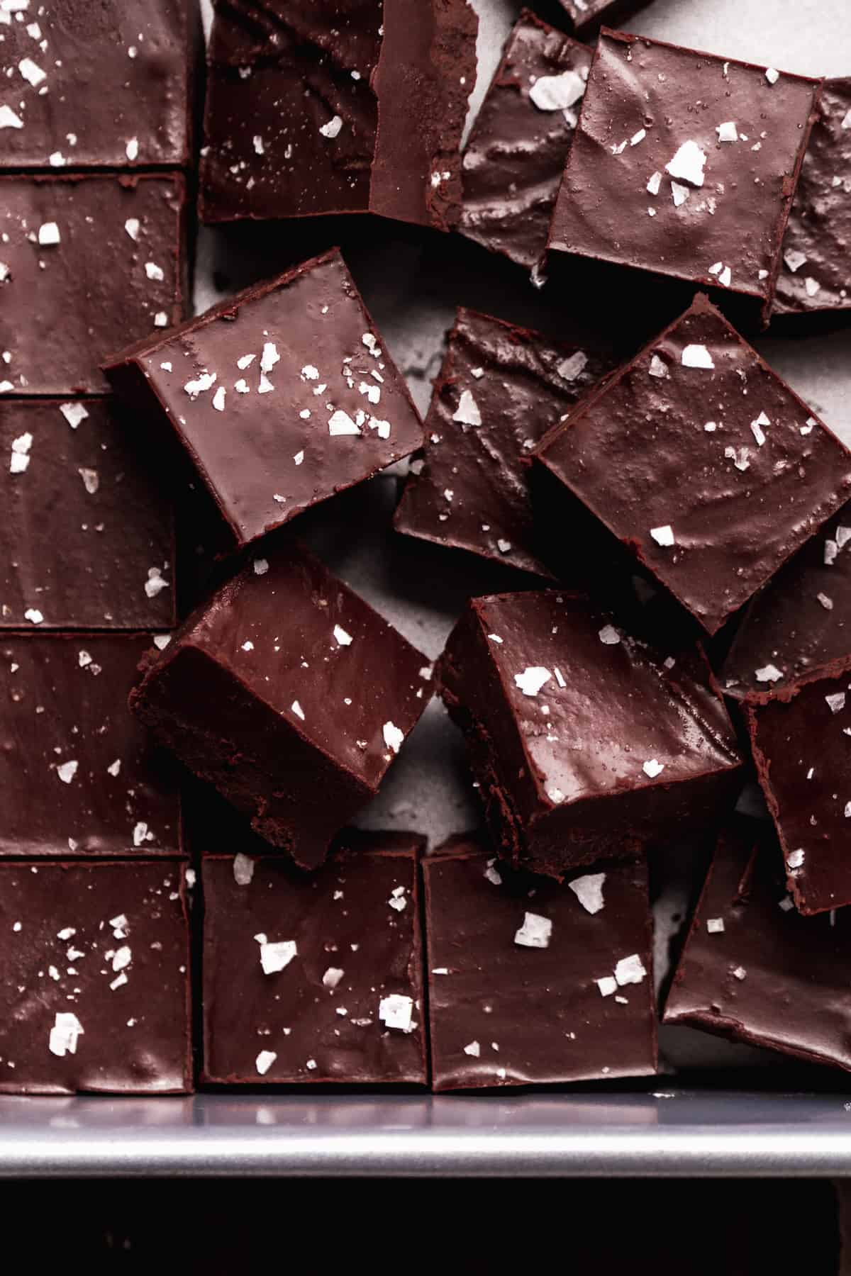 Vegan dark chocolate fudge scattered in a pan.