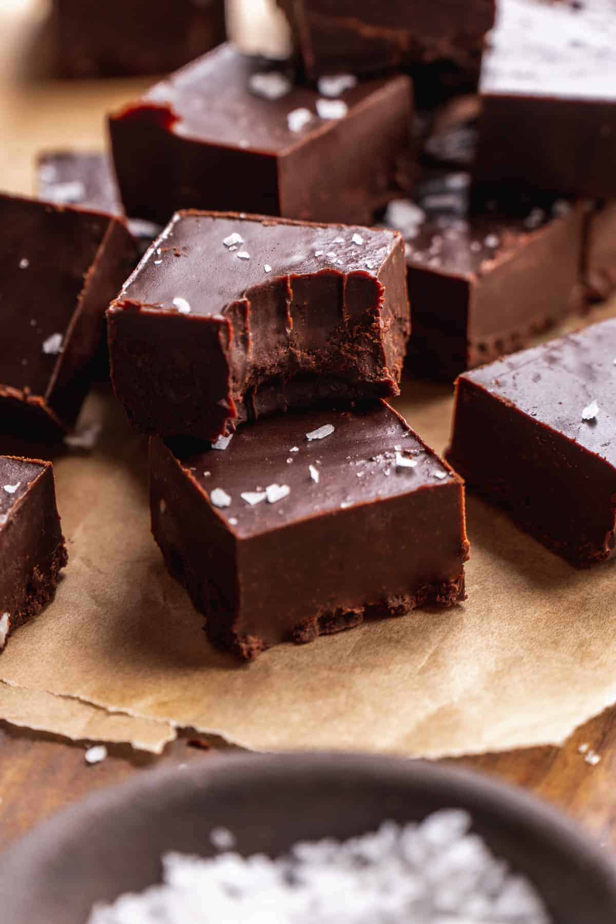 Stack of two pieces of chocolate fudge with a bite taken out of one.