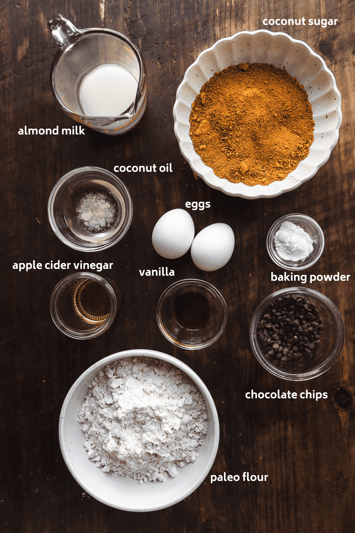 Paleo chocolate chip muffin ingredients on a wooden surface.