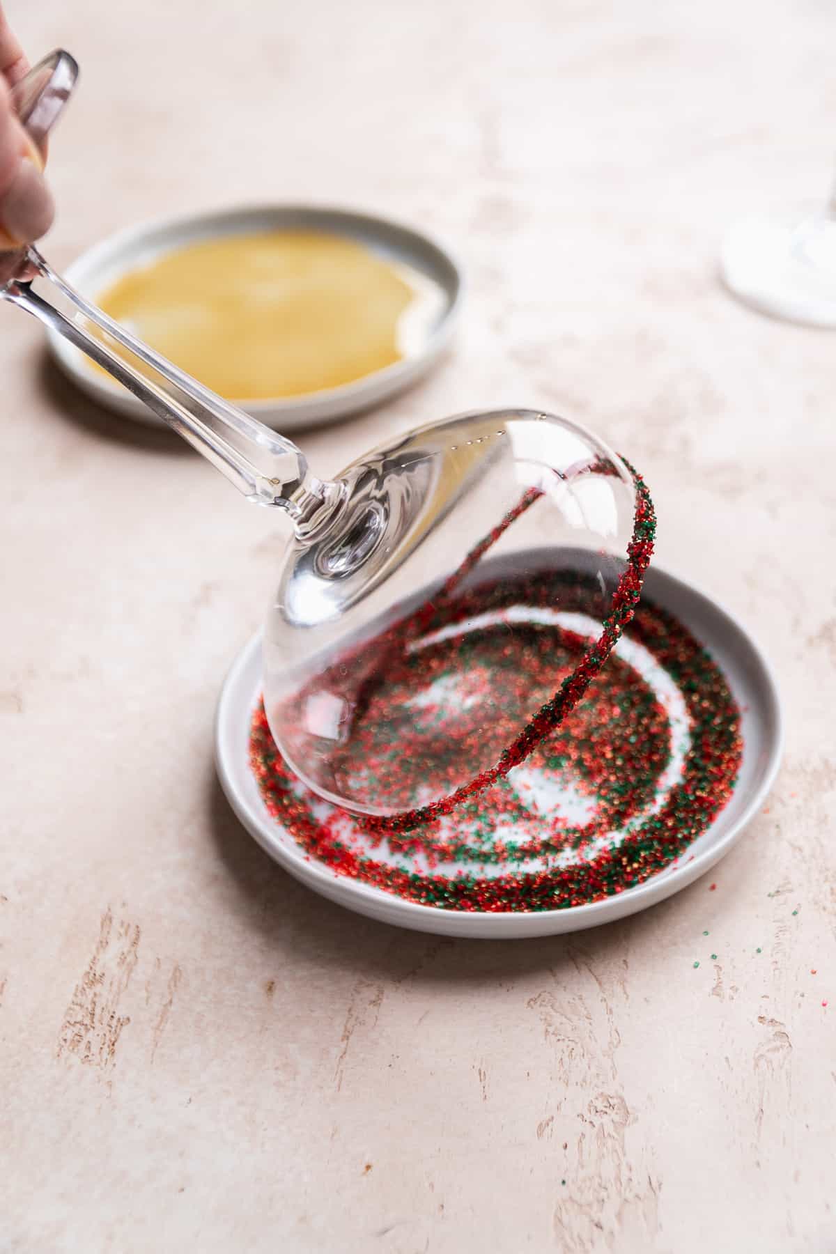 Martini glass being rimmed in sprinkles.