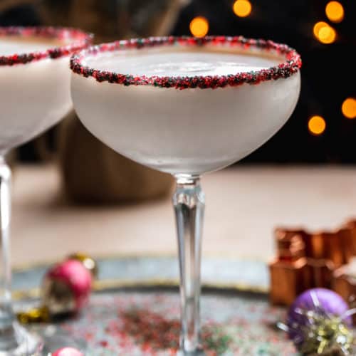 Sugar cookie martini with sprinkle rim on a silver platter.