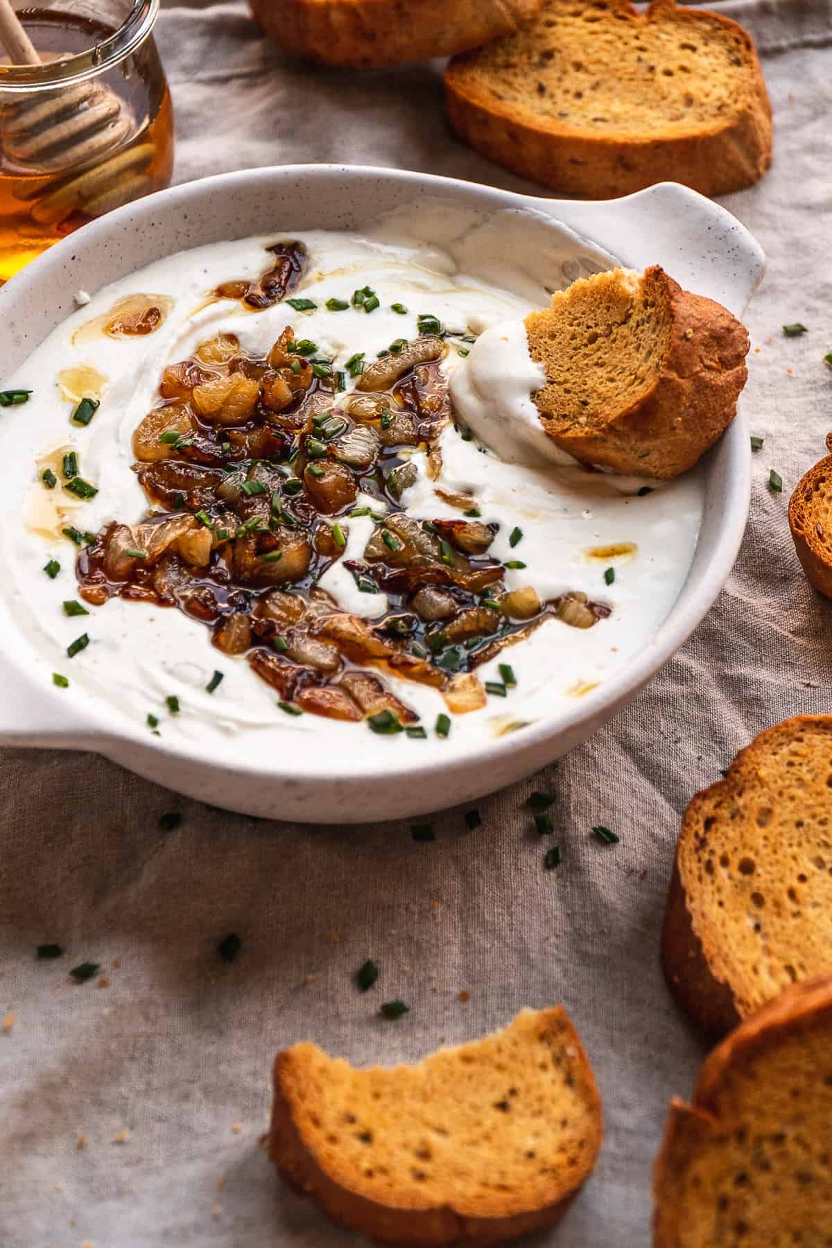 Whipped goat cheese in a dish with bread on the side.