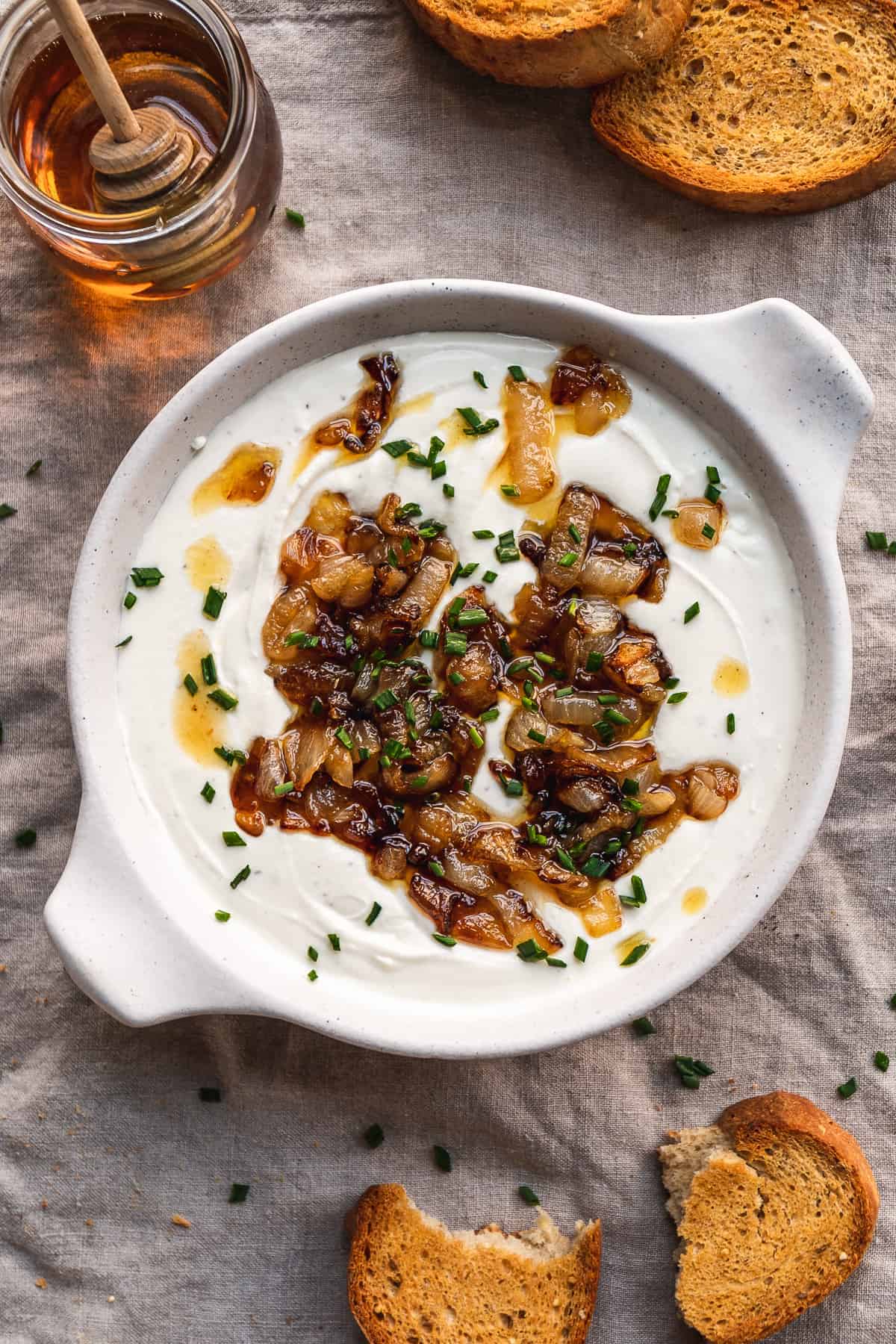 A dish with whipped goat cheese and caramelized onions on top.