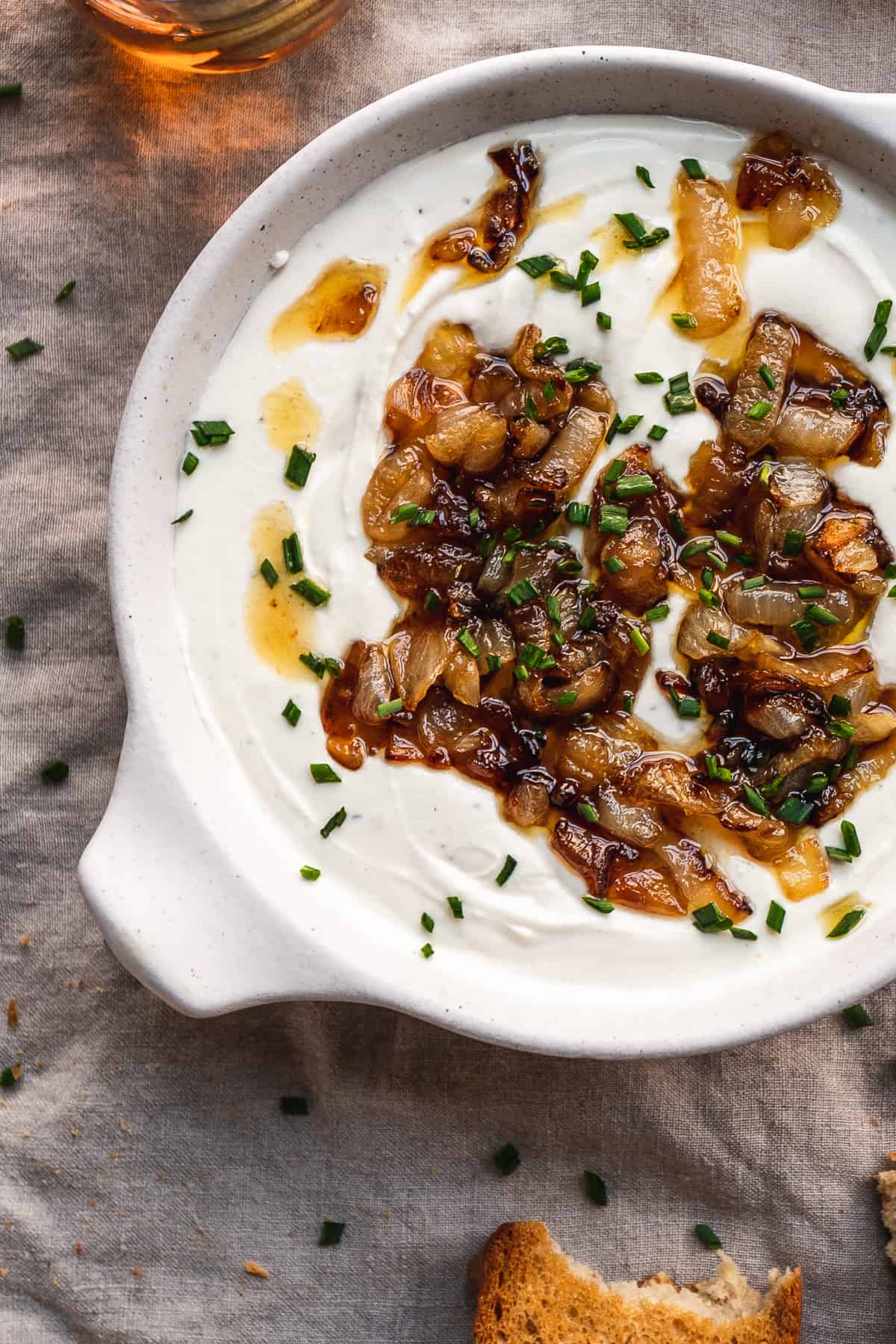 Whipped goat cheese with caramelized onions on top on a gray tablecloth.
