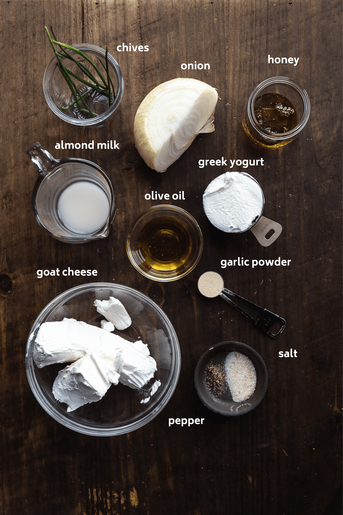 Whipped goat cheese ingredients on a wooden surface with labels in white.