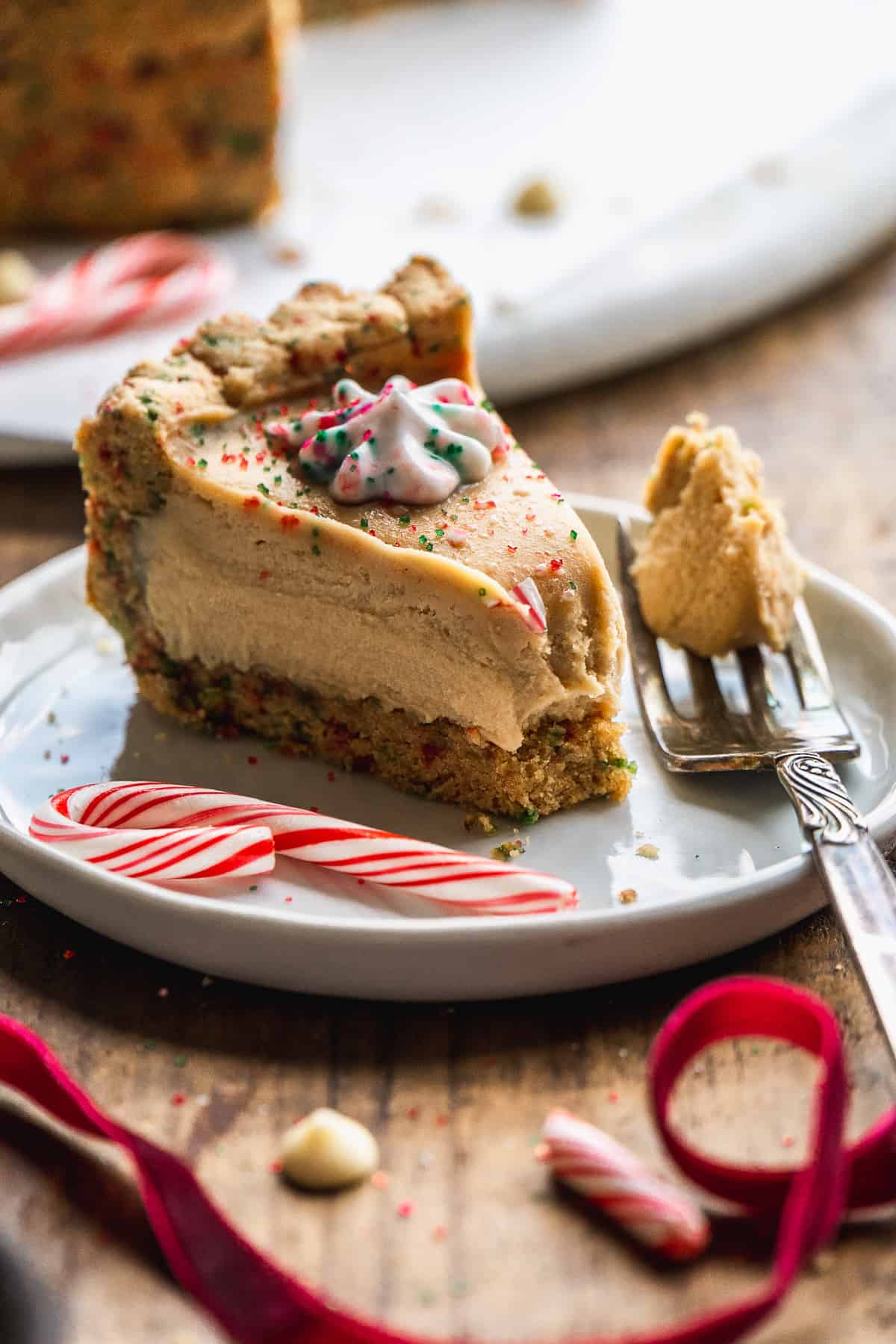 A slice of candy cane pie on a white plate with a fork taking a bite out of the pie.