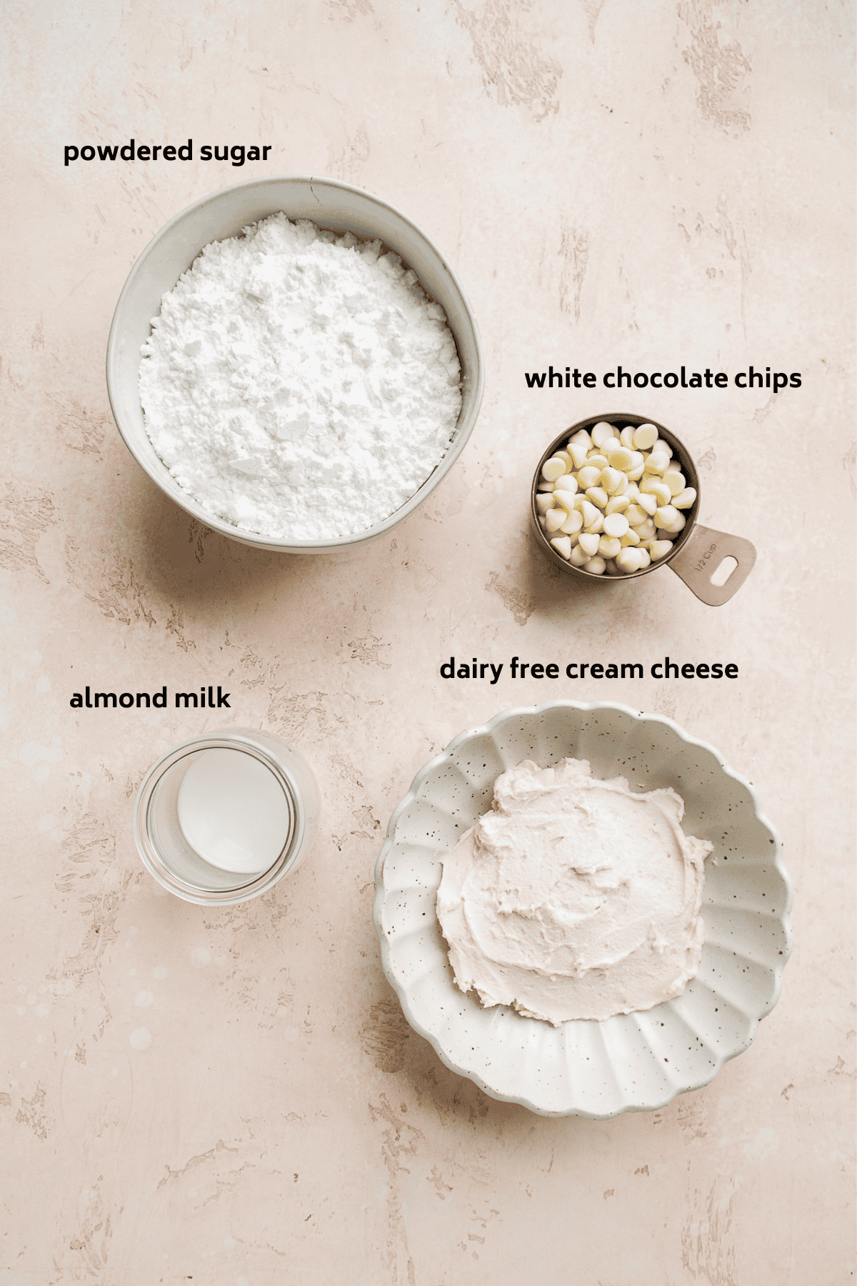 Cream cheese frosting ingredients on a pink surface.