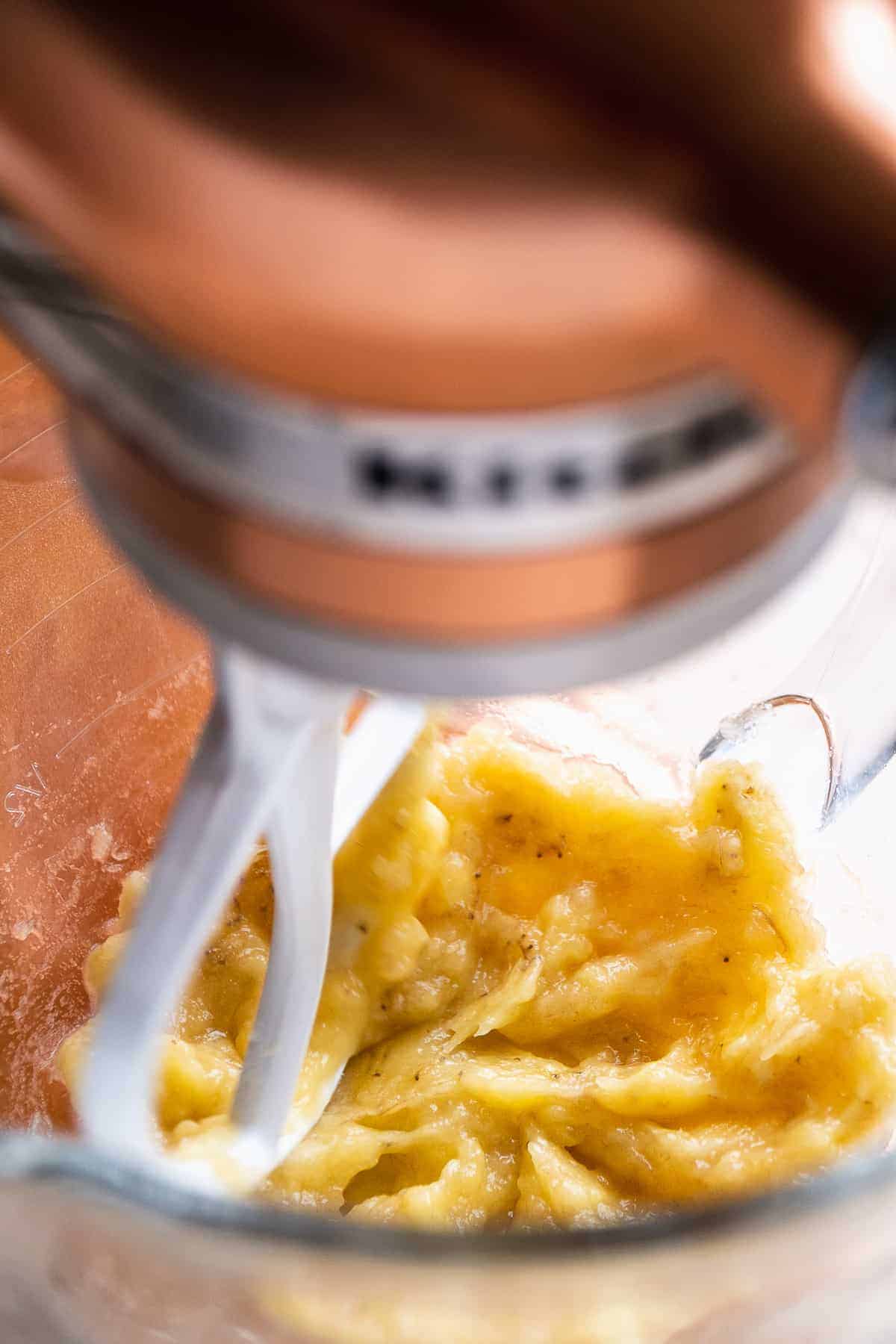 Banana mixture being mixed in a large glass bowl.