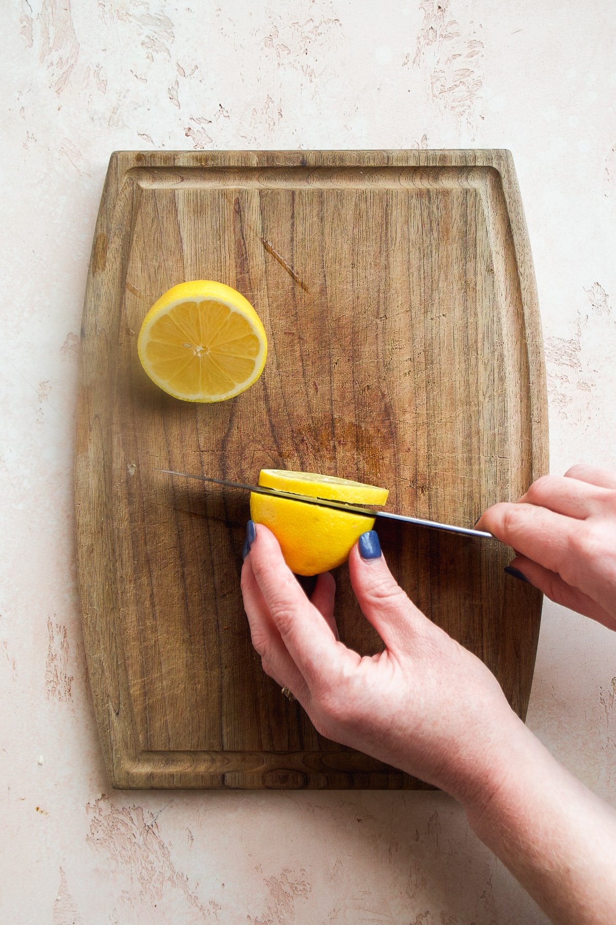 Person cutting sliver from a lemon.