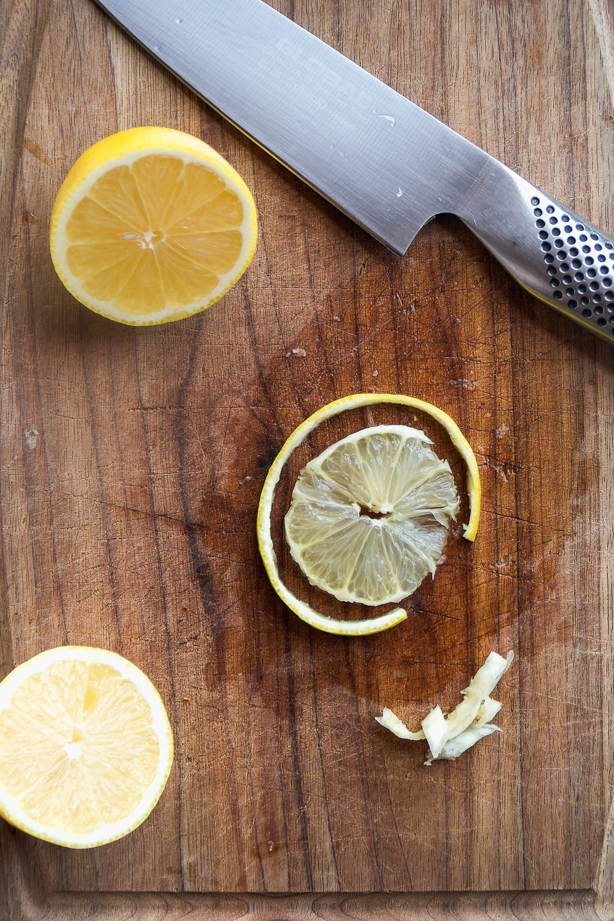 Lemon slice on a wooden cutting board with the rind cut off.