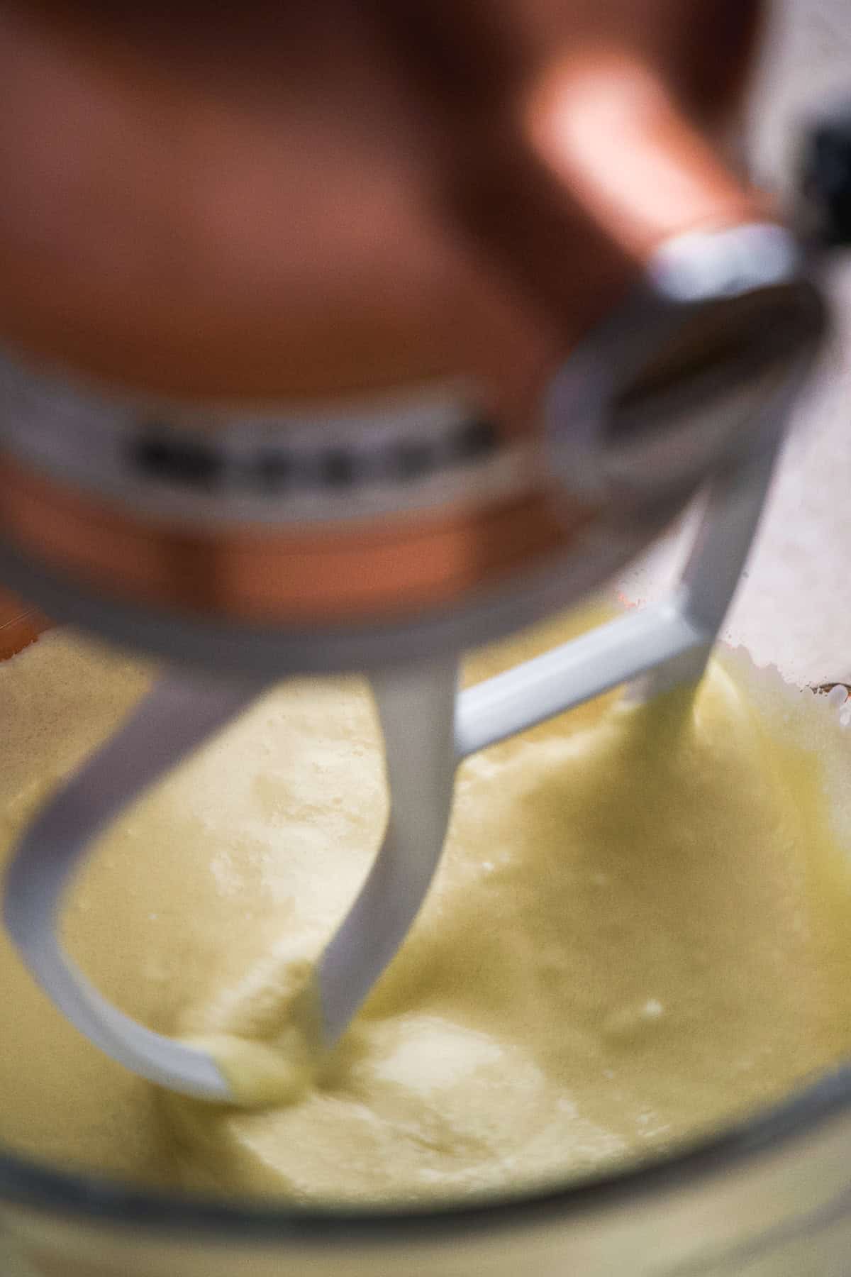 A cream mixture in a stand mixer.