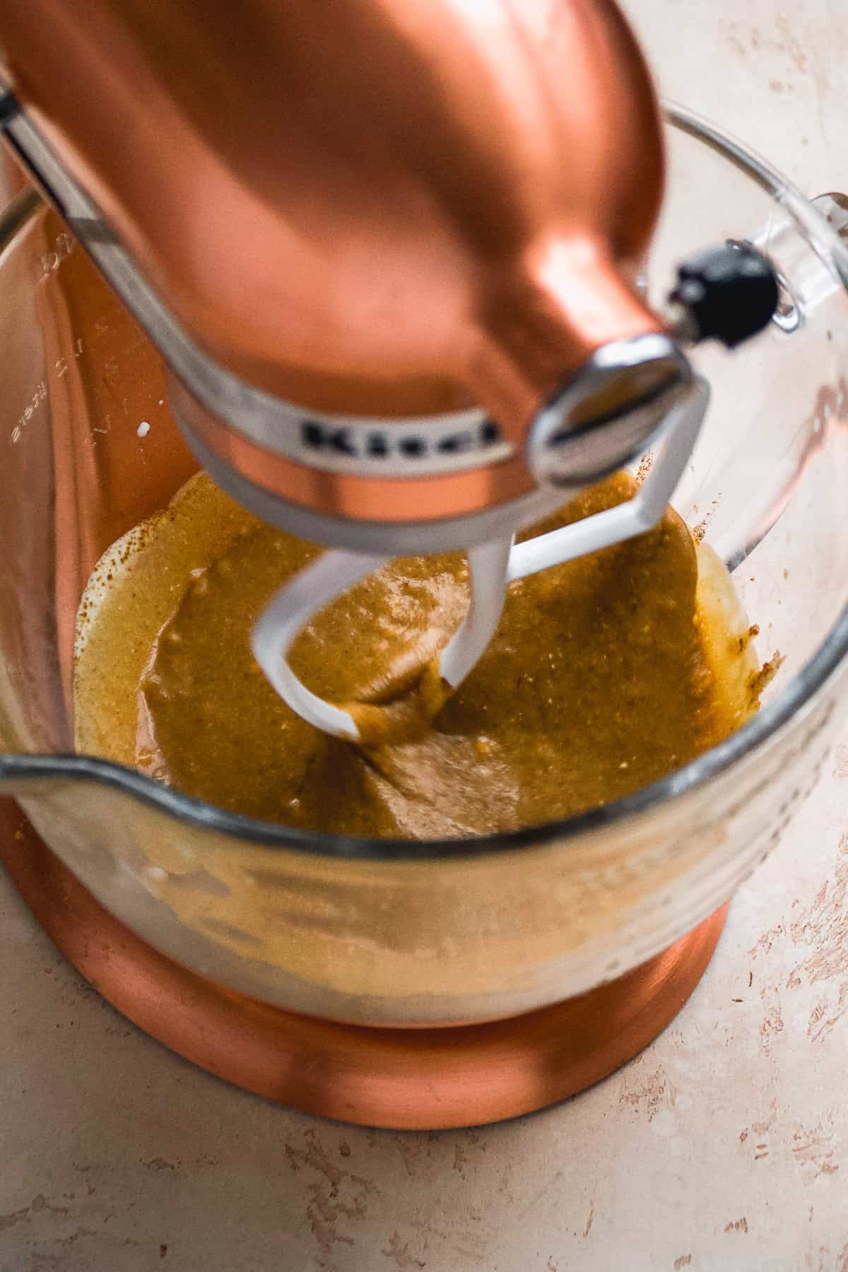 Cupcake batter in a mixing bowl being mixed.