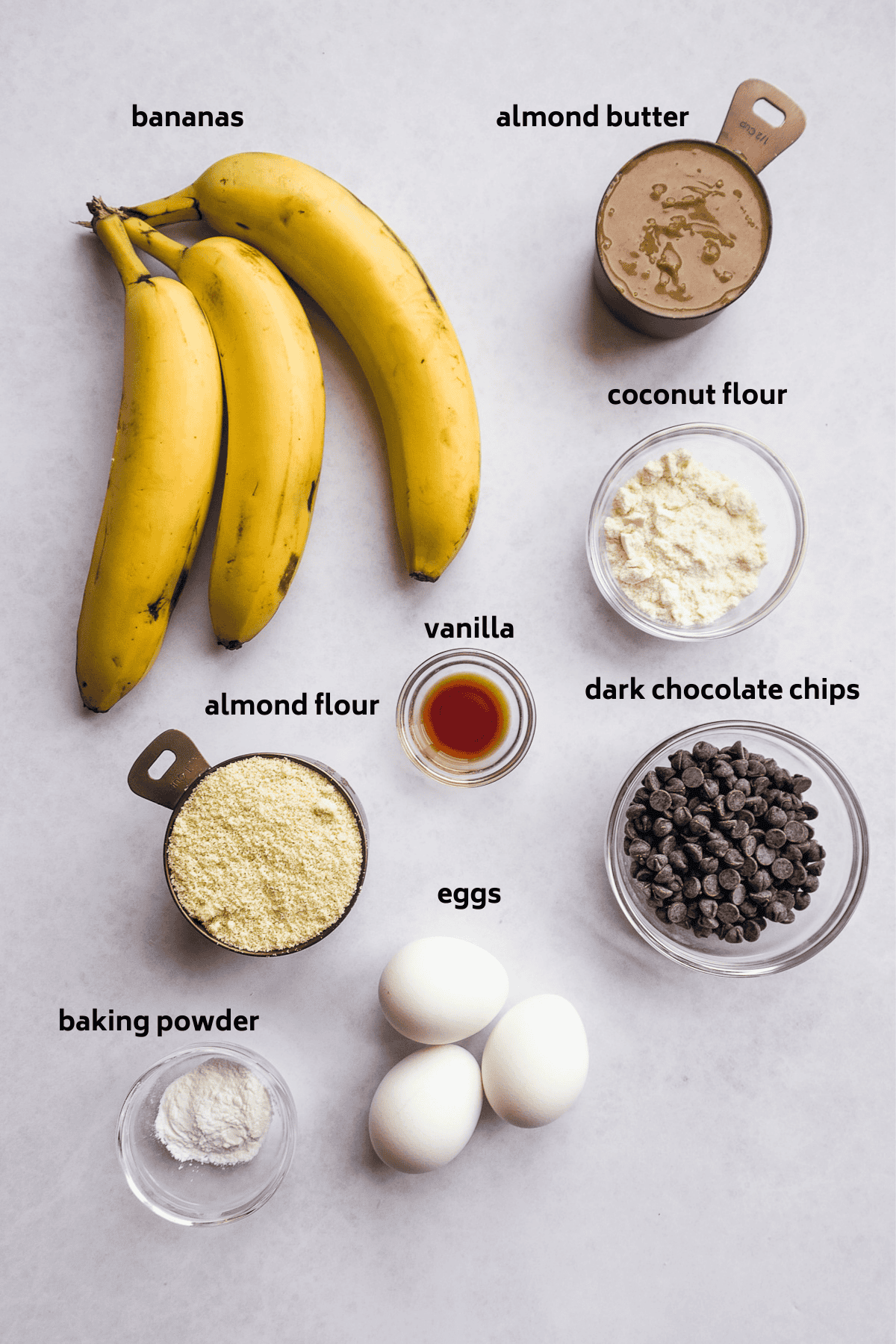 Mini banana muffin ingredients on a blue surface.