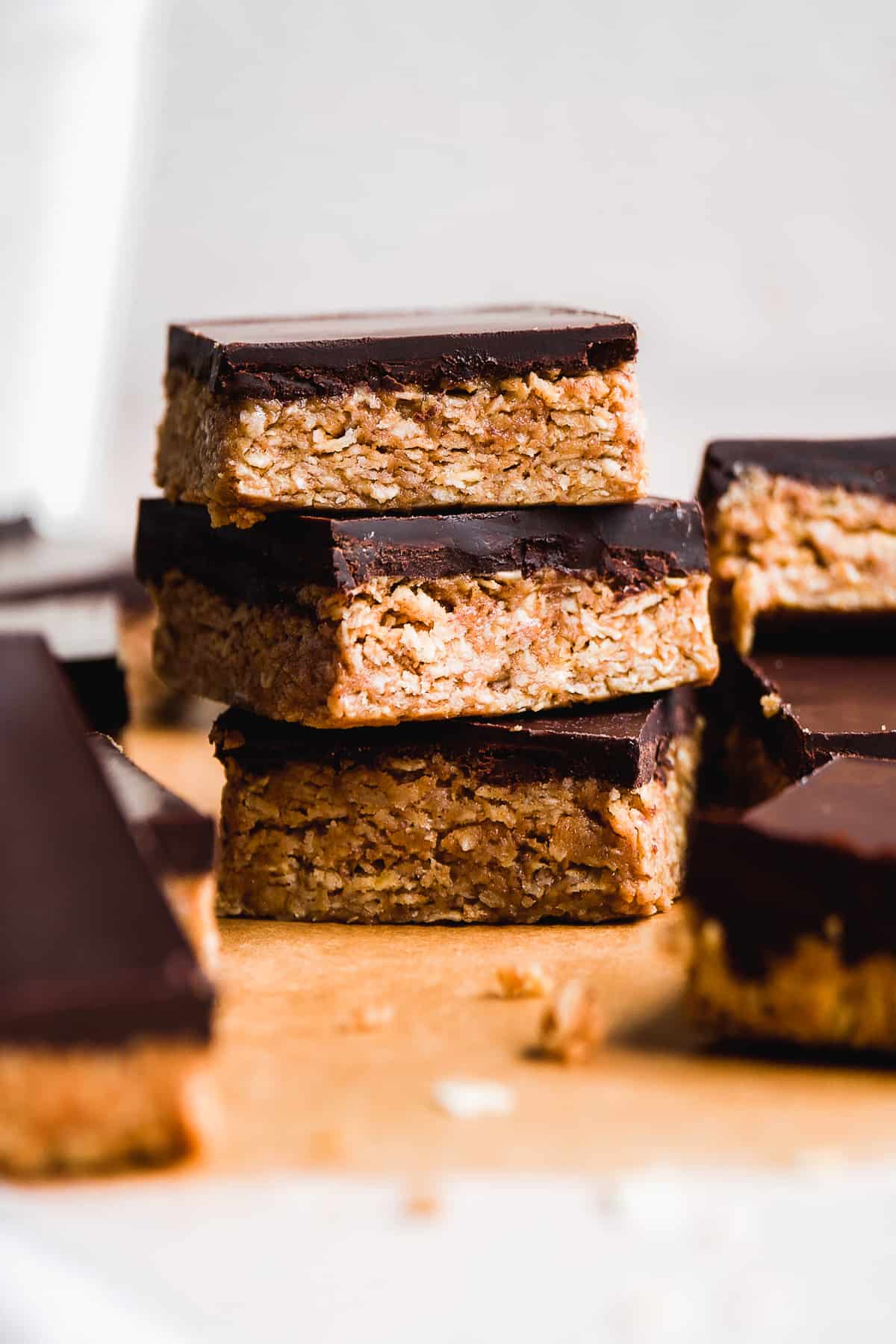 Stack of chocolate peanut butter oatmeal bars on parchment paper.