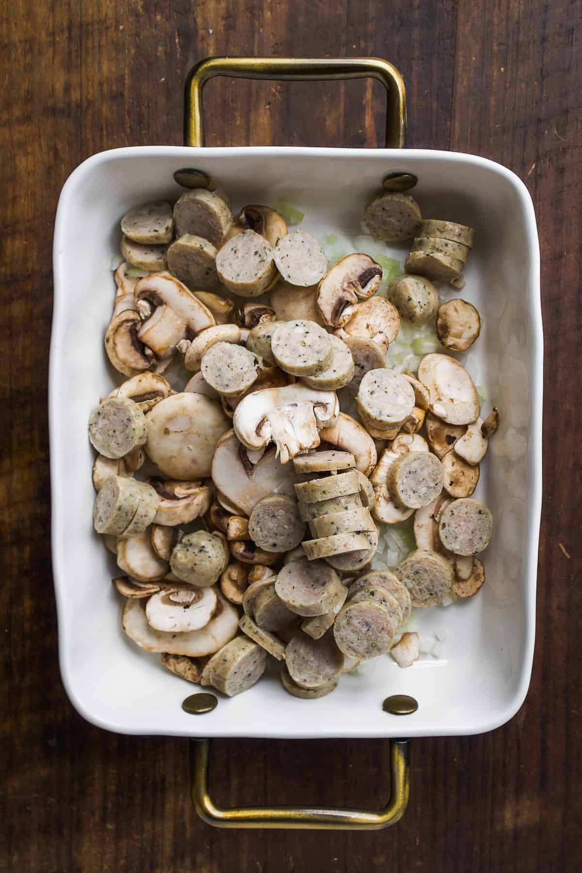 White dish with sausage and mushrooms.