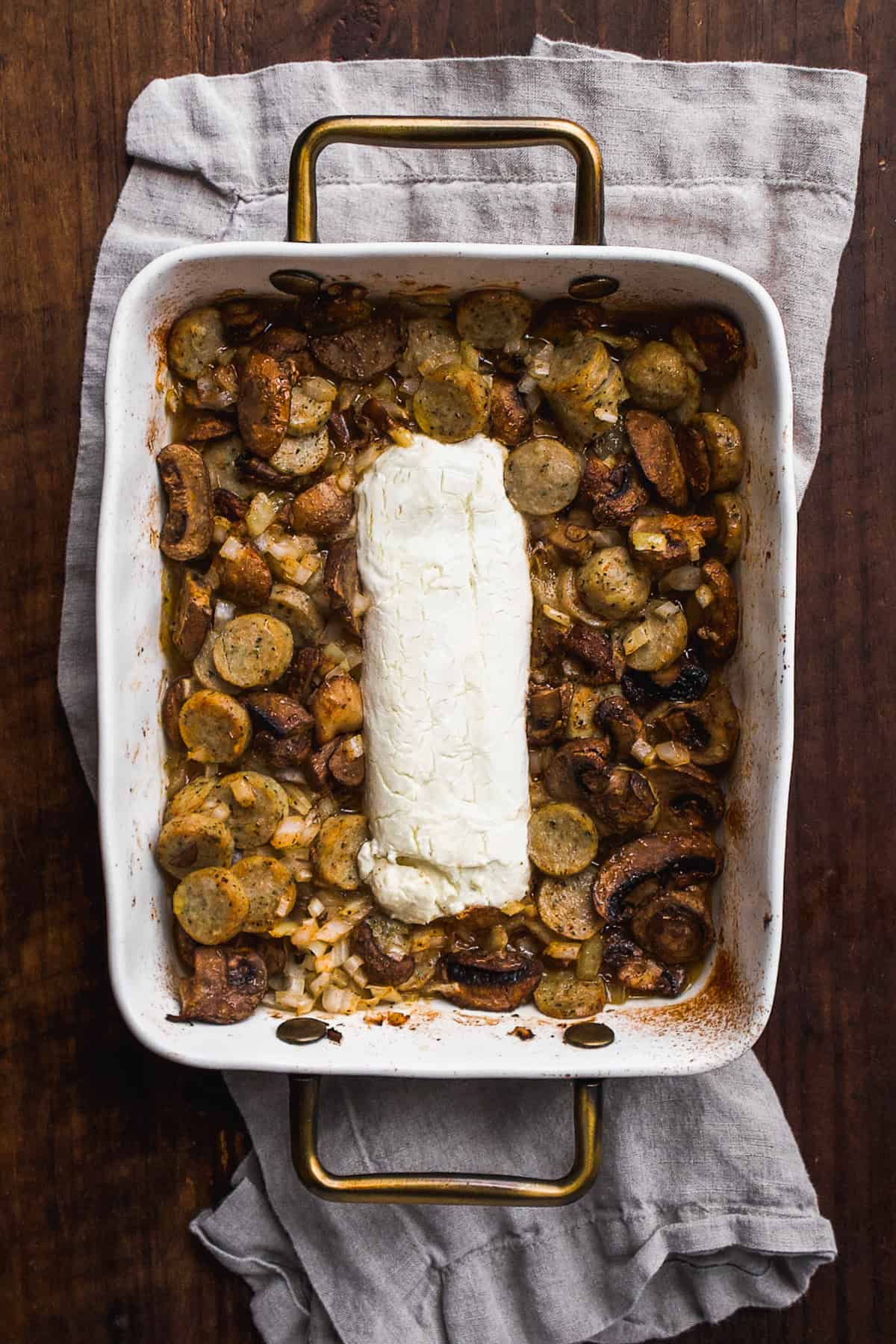 Baked goat cheese in a white baking dish.