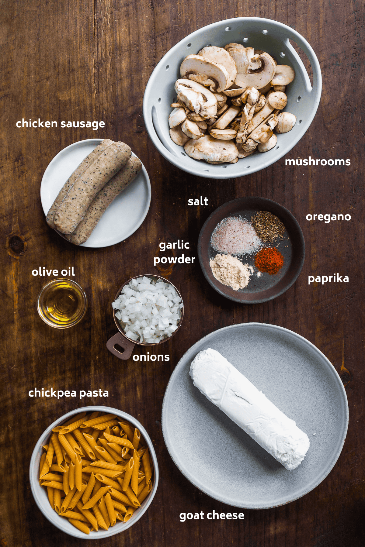 Baked goat cheese pasta ingredients on a wooden surface.