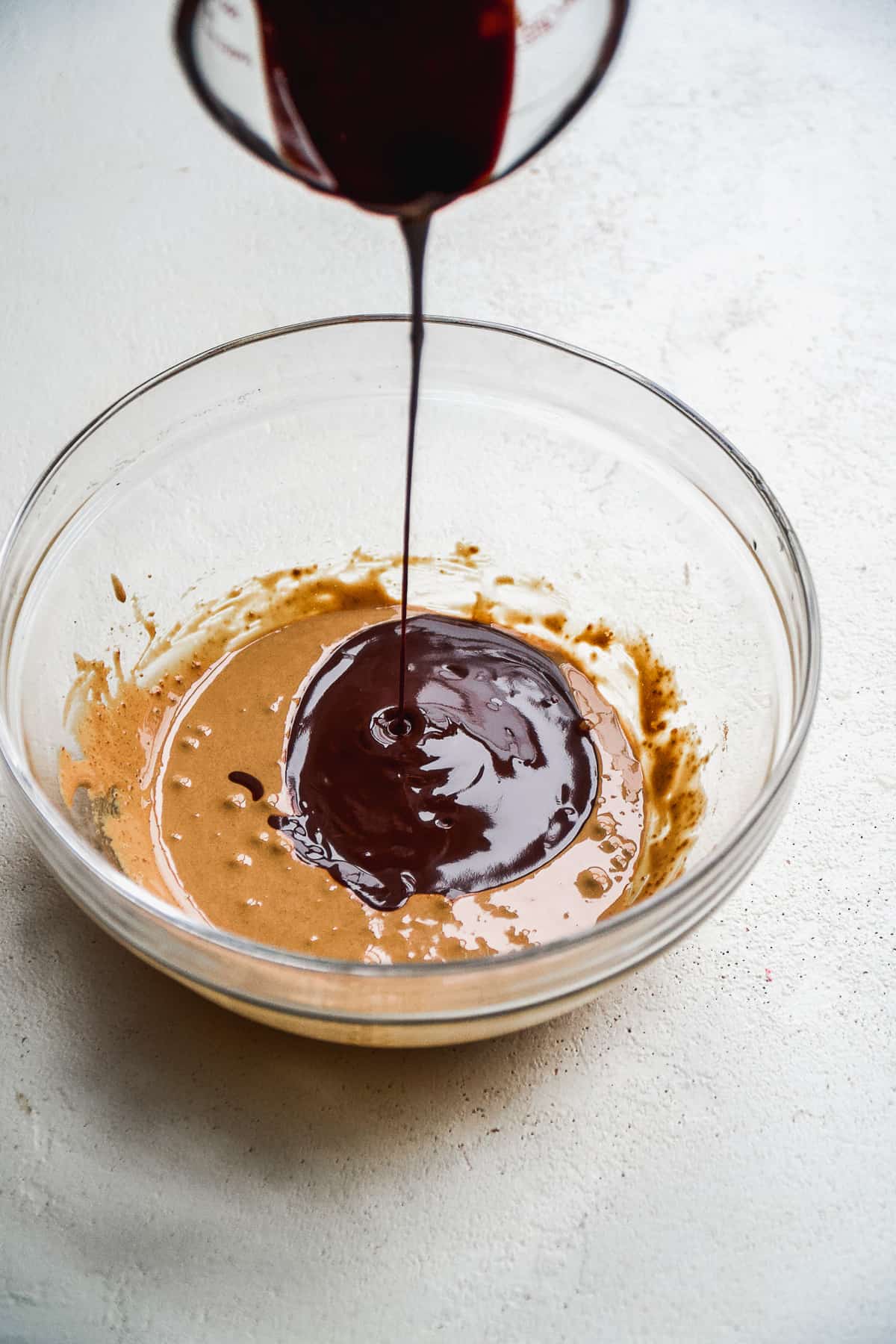 Melted chocolate being poured into a mixing bowl.