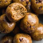Cookie dough protein balls in a pile with a bite taken out of one.