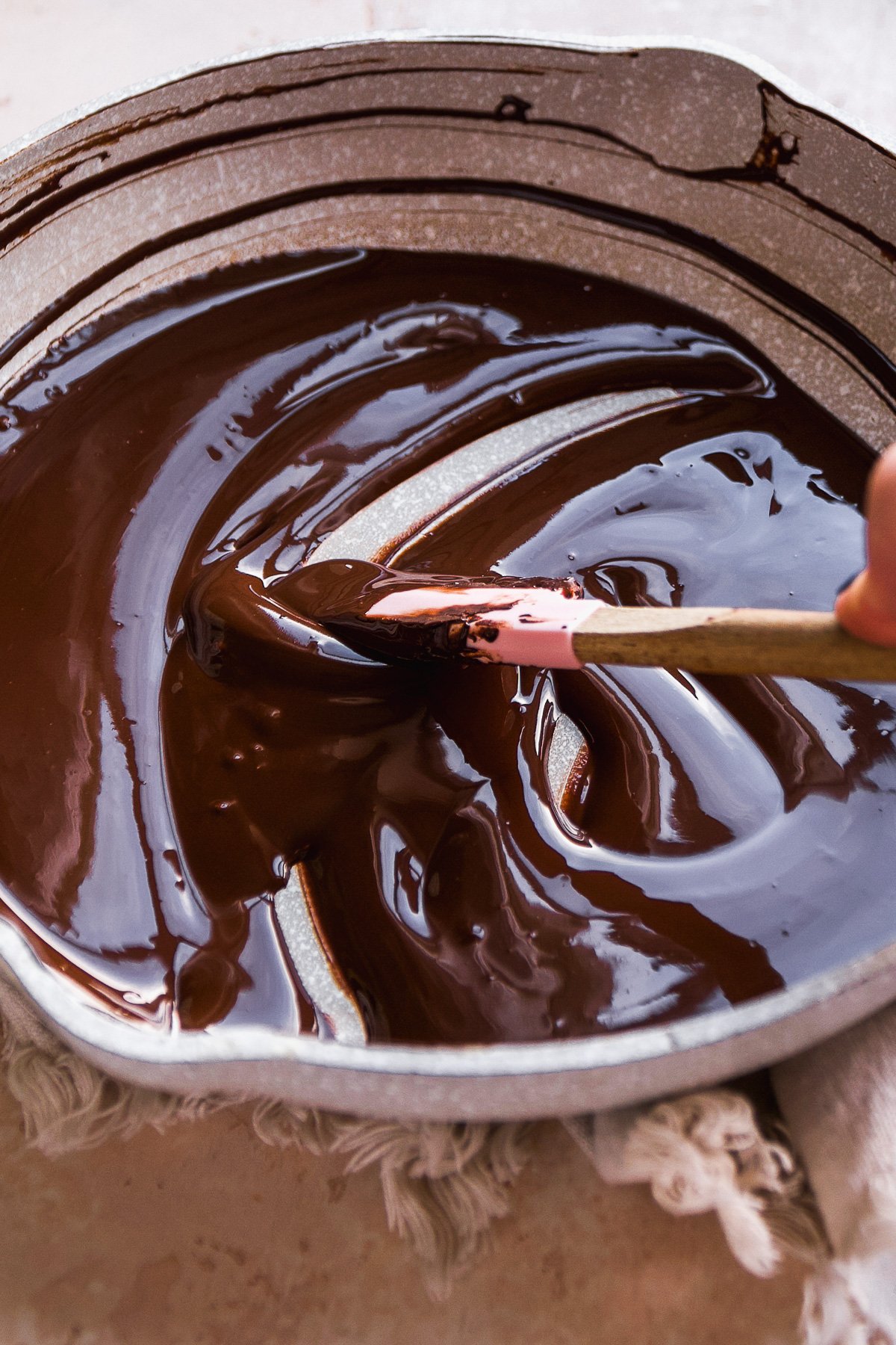 Person melting chocolate in a sauce pan.