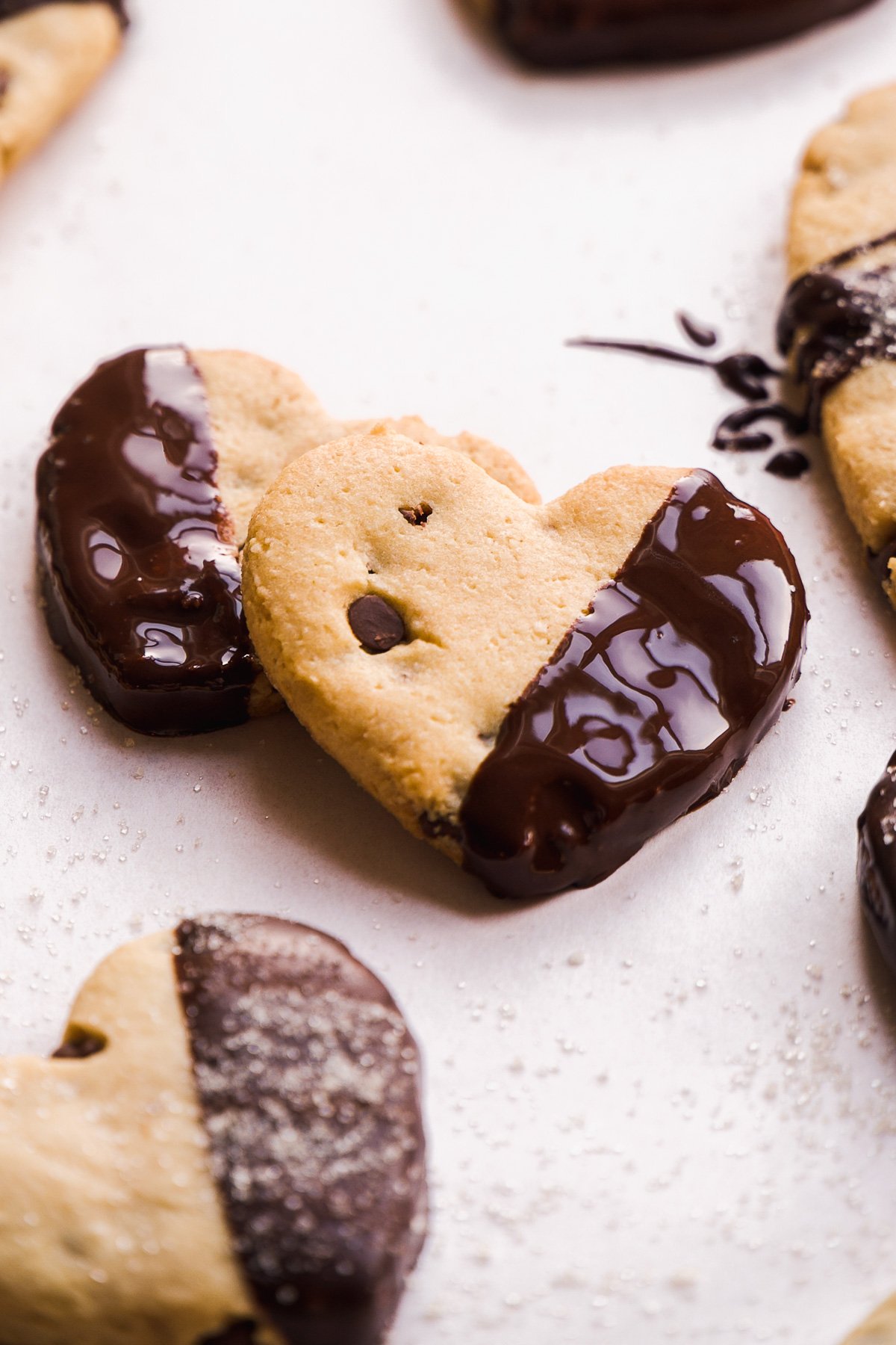 Mini heart cookies half way dipped into melted chocolate.